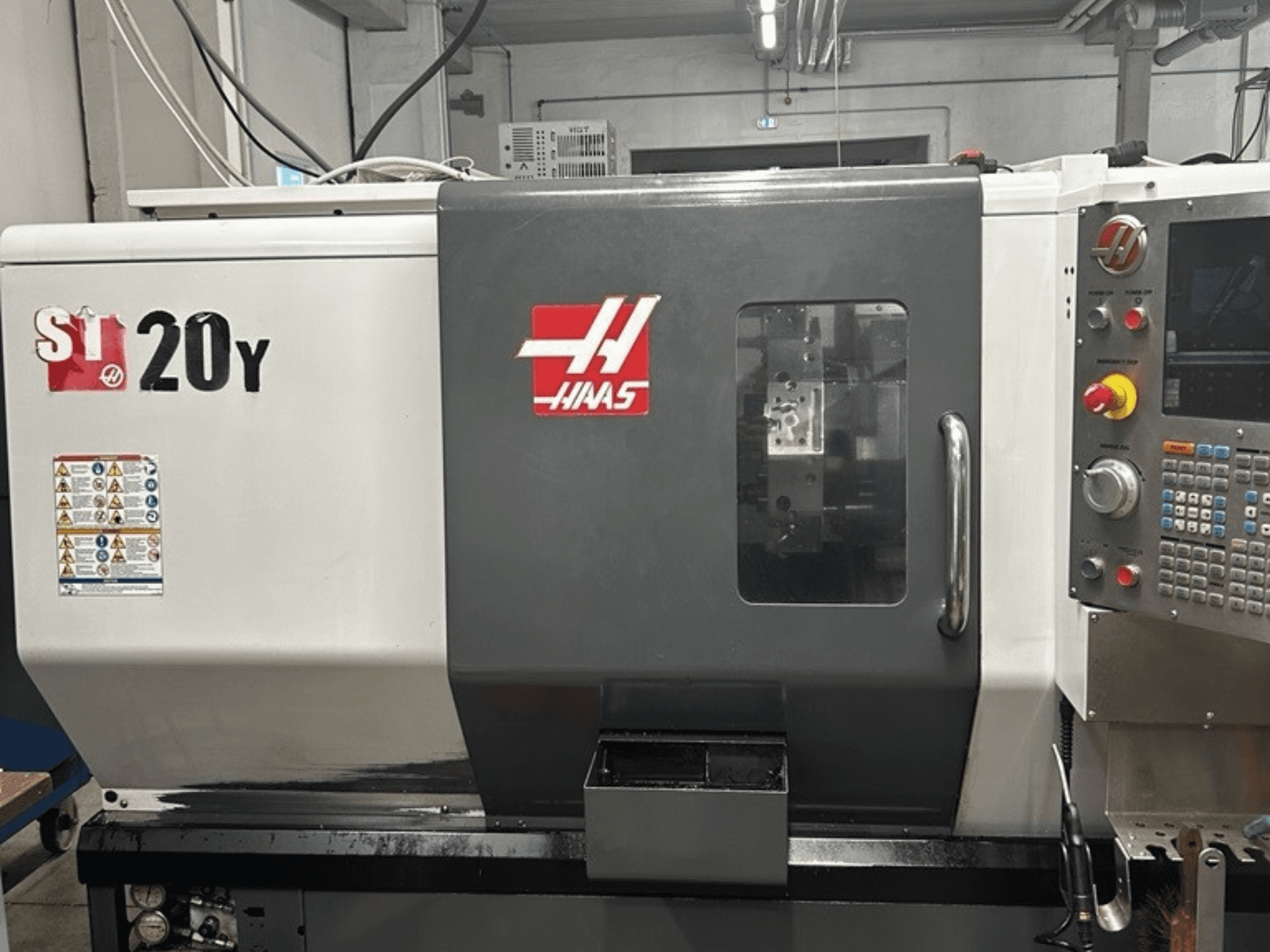 Haas ST-20Y CNC-Drehmaschine, Vorderansicht, mit Bedienfeld, Sicherheitsschildern und Betriebsfenster.