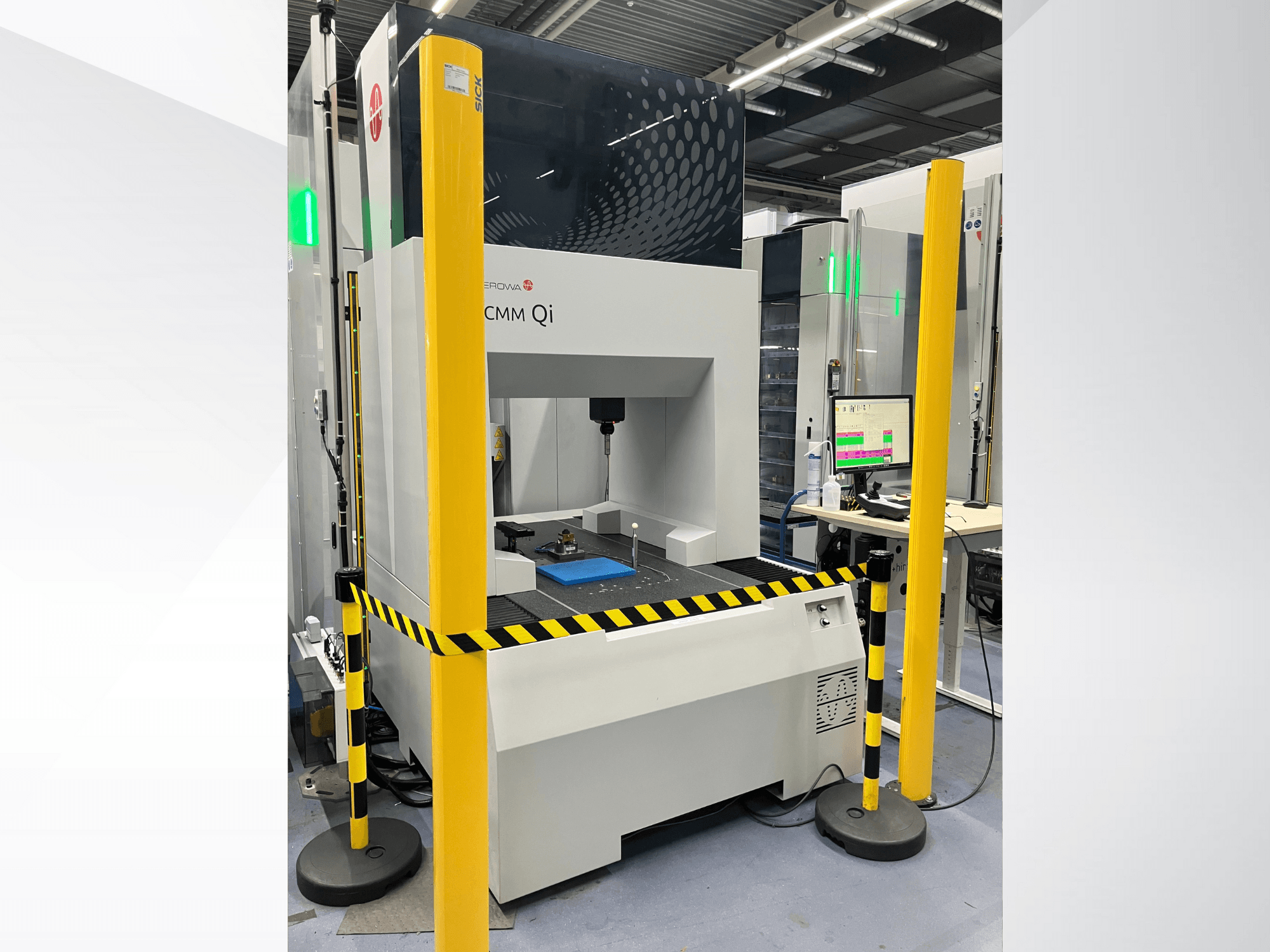 CMM Qi coordinate measuring machine by Aerovent, front view with safety barriers and monitor displaying measurement data.