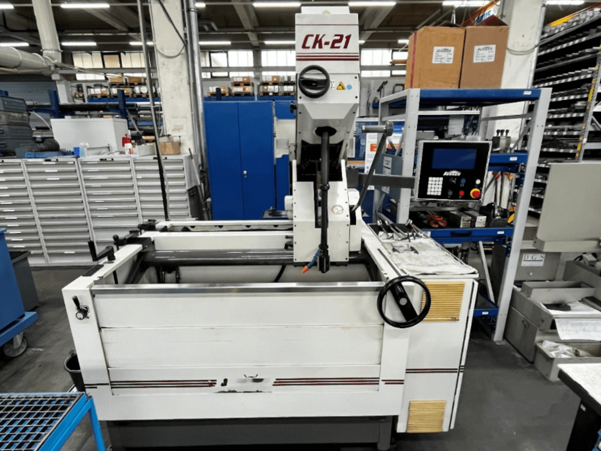 Vertikale Honmaschine CK-21-CC von Sunnen in der Vorderansicht, mit Bedienelementen, Honbereich und Hilfsgeräten im Hintergrund.