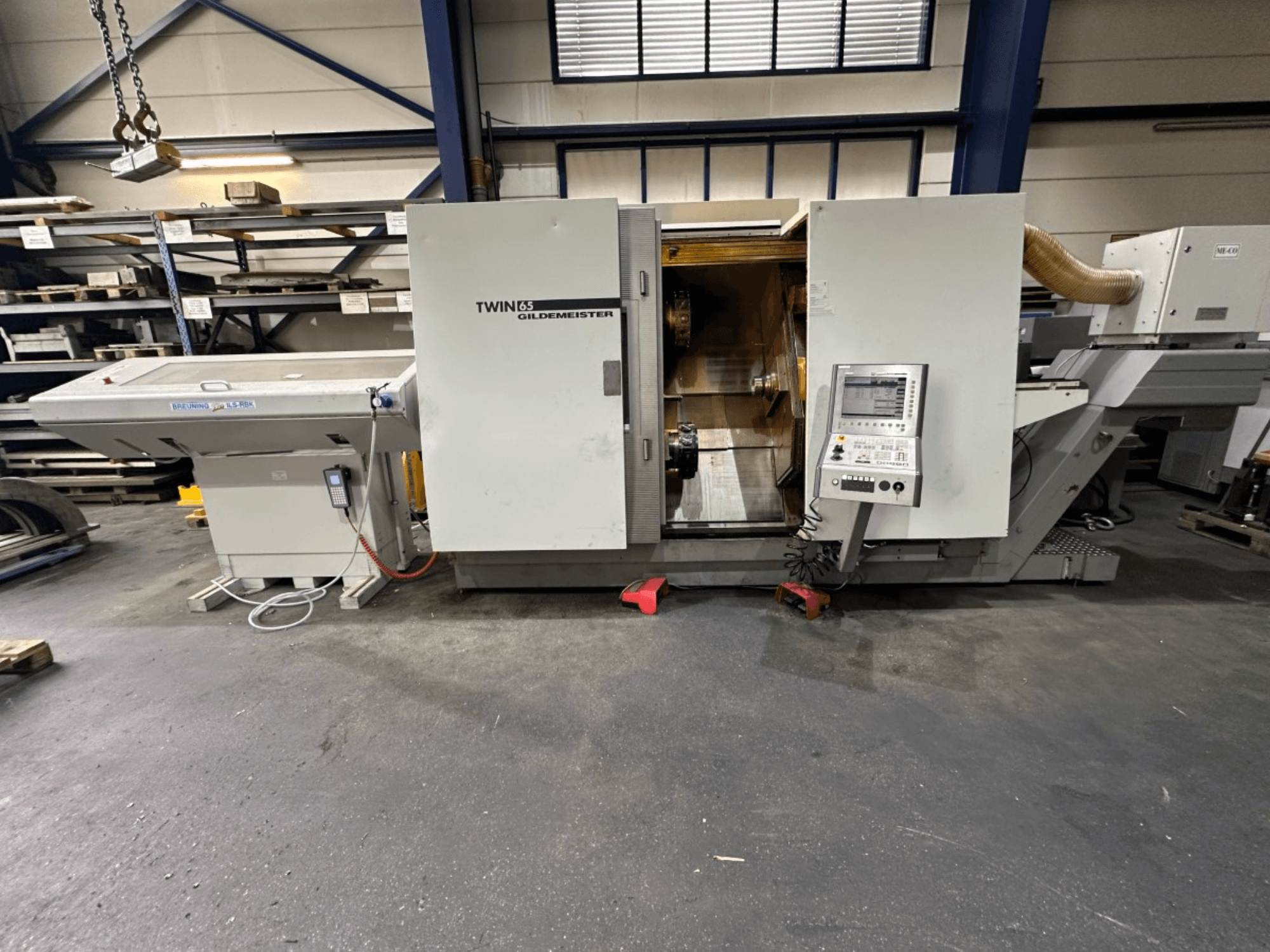 Gildemeister TWIN 65 Horizontal-Drehmaschine, Vorderansicht; mit Bedienpult und sichtbarem Innenraum für die Teilebearbeitung.