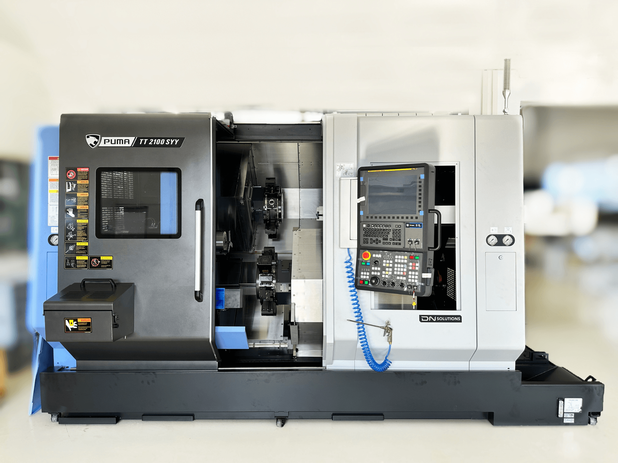 Dreh-Fräszentrum DN SOLUTIONS PUMA TT2100SYY Frontansicht, mit Bedienfeld und sichtbaren Innenkomponenten.