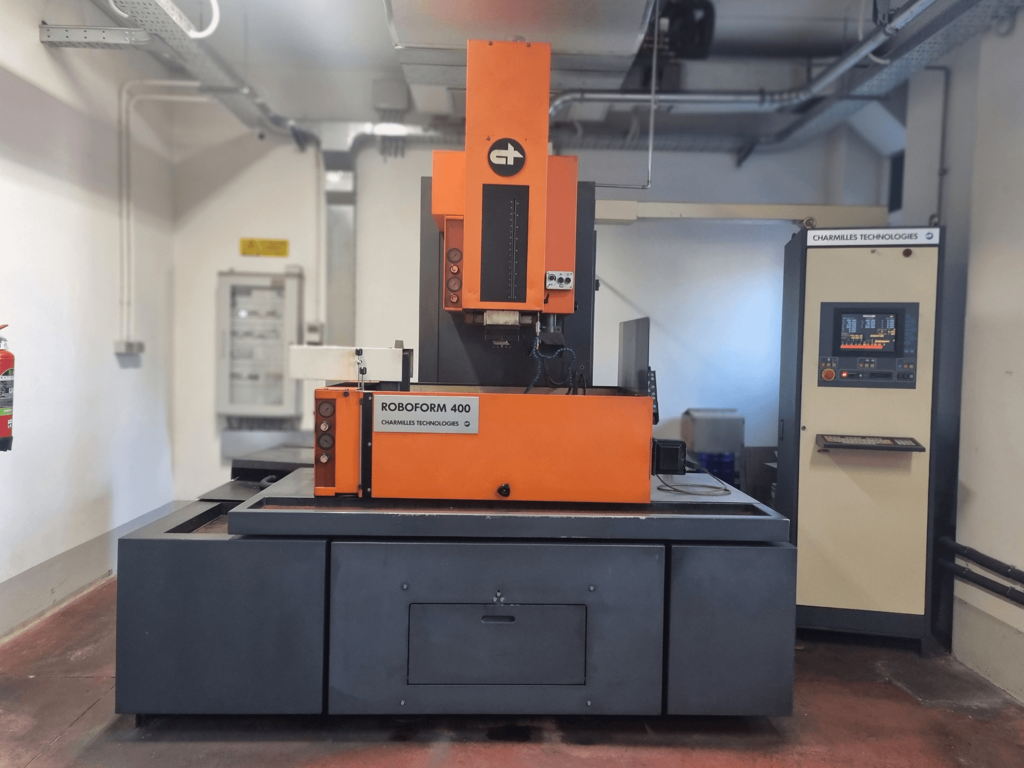 Roboforn 400 von Charmilles Technologies, Vorderansicht, in orange-grauem Design, digitales Bedienfeld sichtbar.