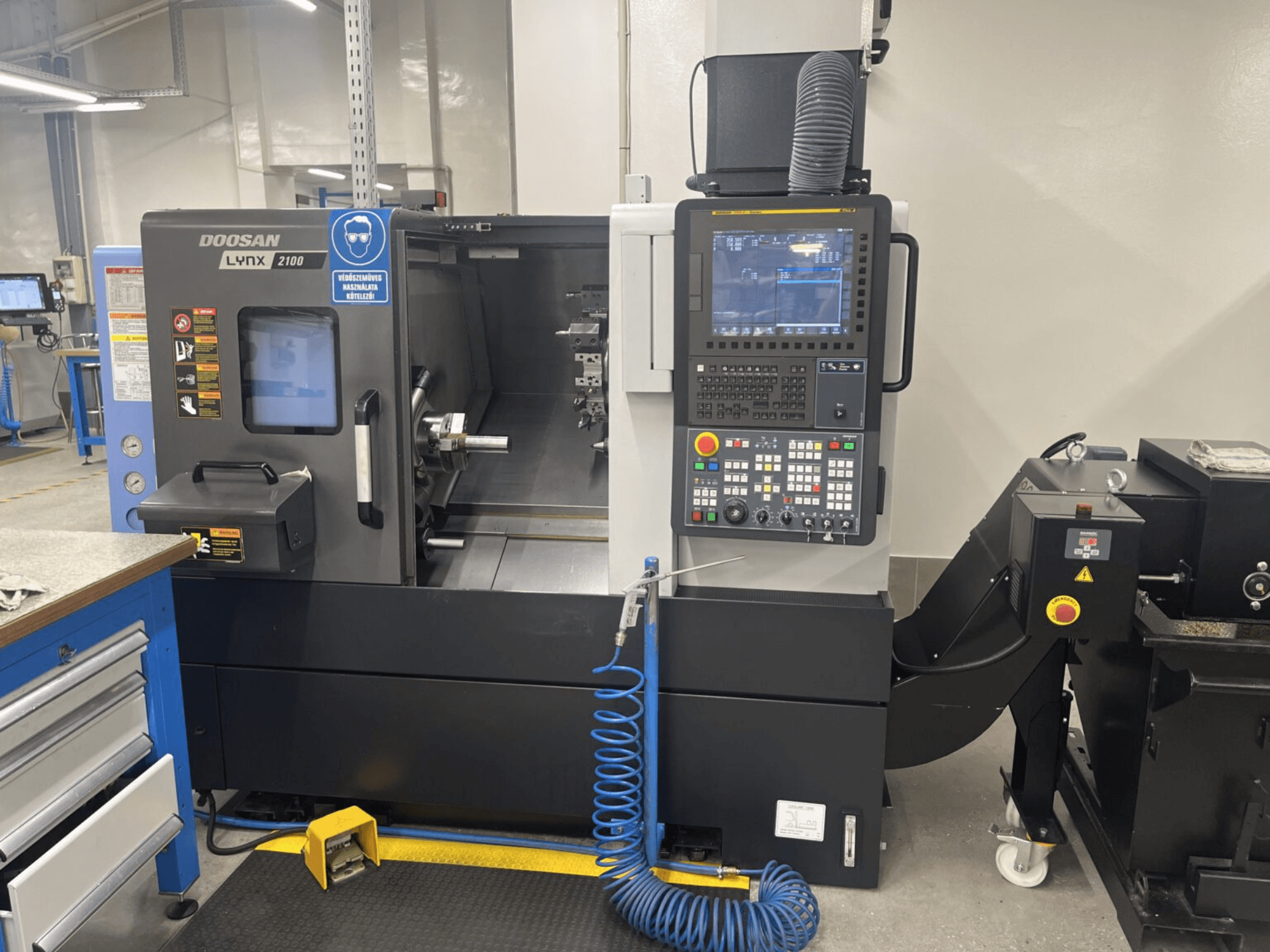 Vorderansicht einer DOOSAN Lynx 2100A Horizontal-Drehmaschine mit Bedienfeld und Spindelbereich mit bemerkenswerten Sicherheitsmerkmalen.