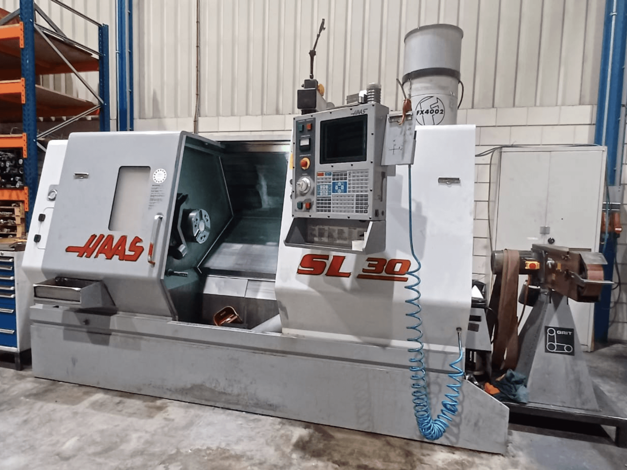 Haas SL 30 CNC-Drehmaschine in der Seitenansicht, mit Bedienfeld, Bearbeitungsbereich und integriertem Kühlmittelsystem für die Metallbearbeitung.