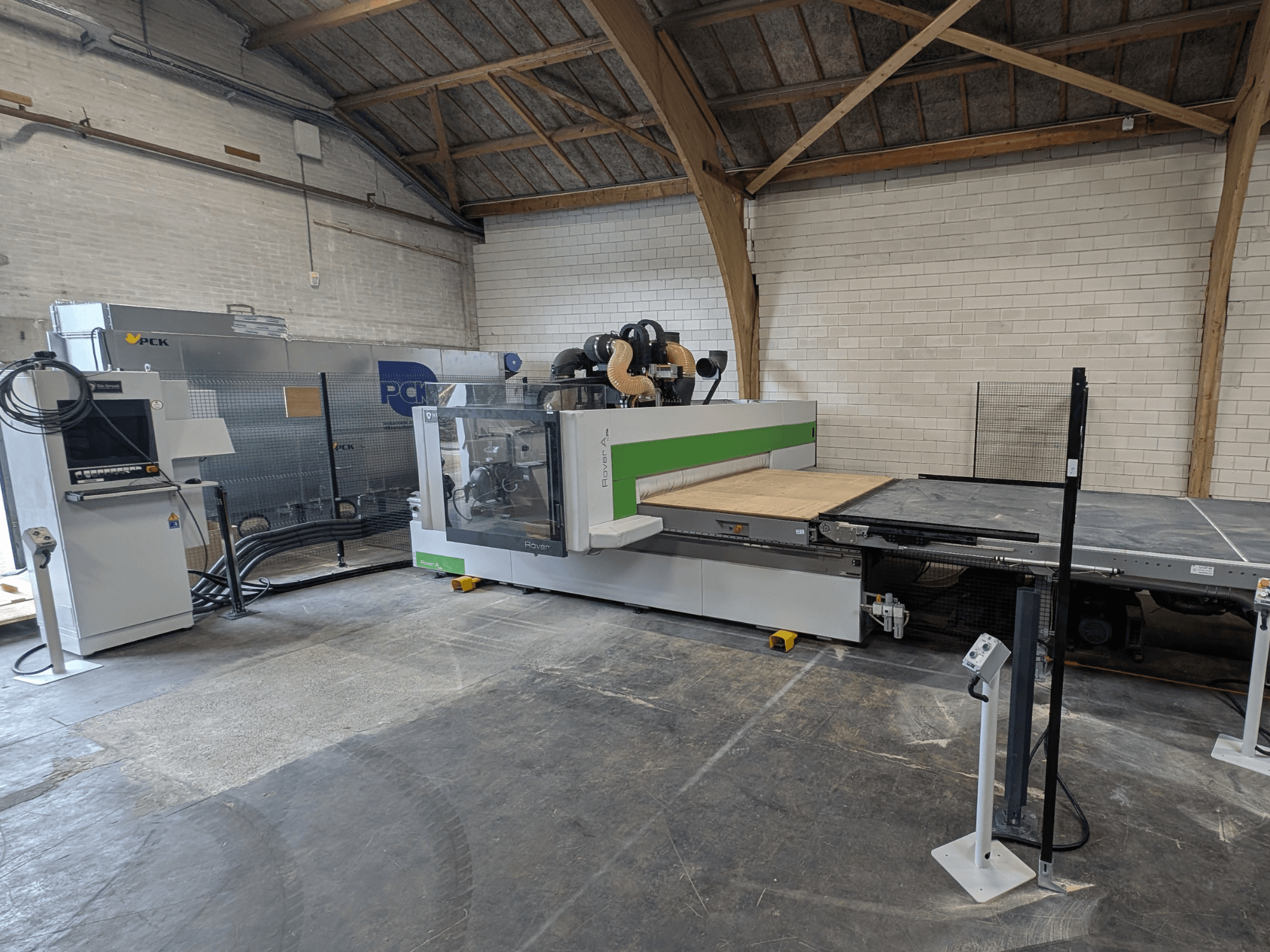 PCK CNC machining center, front view, features a large cutting bed, control panel, dust extraction system, and robust design.