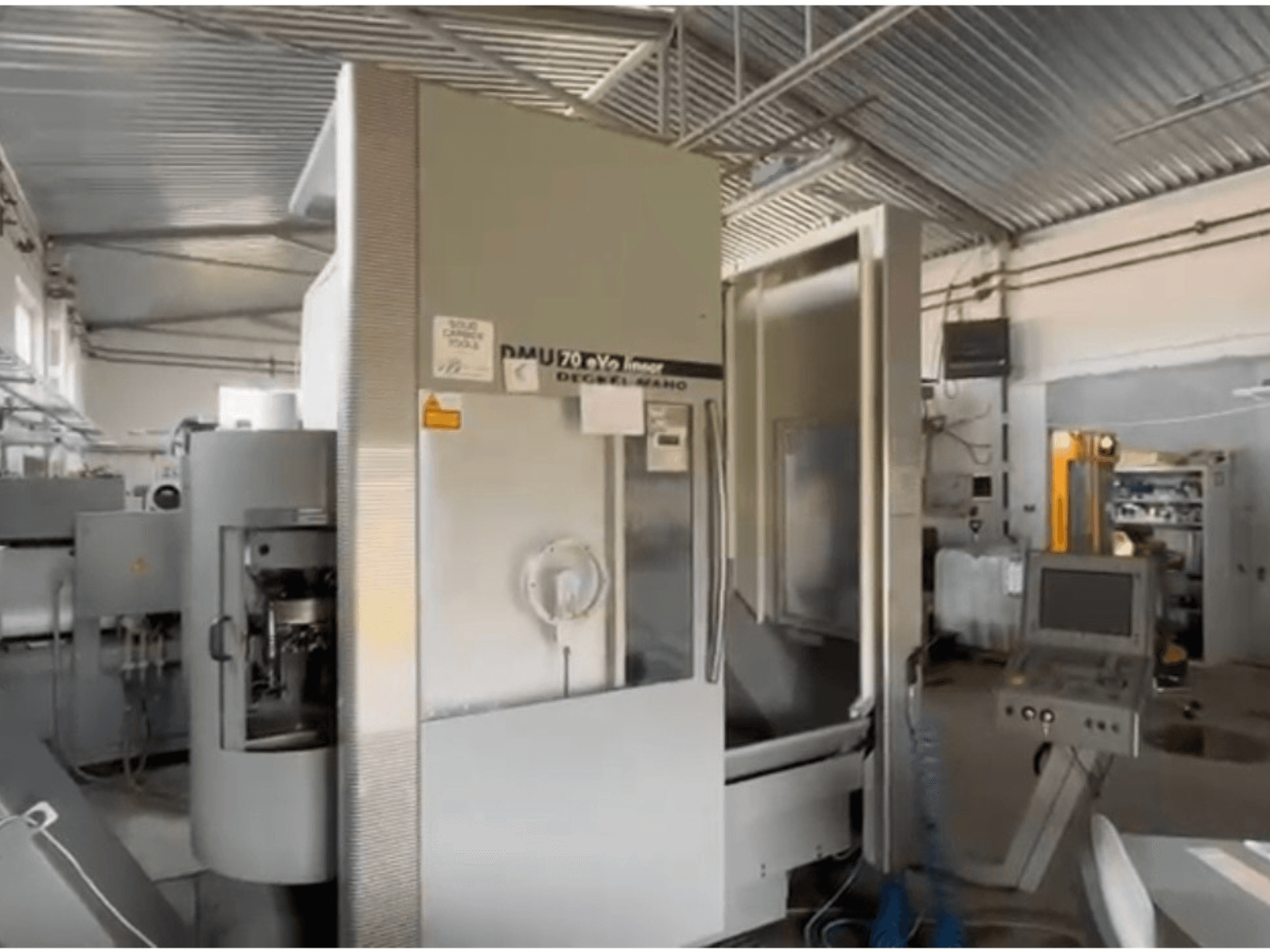 Lineare CNC-Maschine DMU 70 eVo in einer Werkstatt, Vorderansicht, mit einem Bedienfeld und modernem Design.