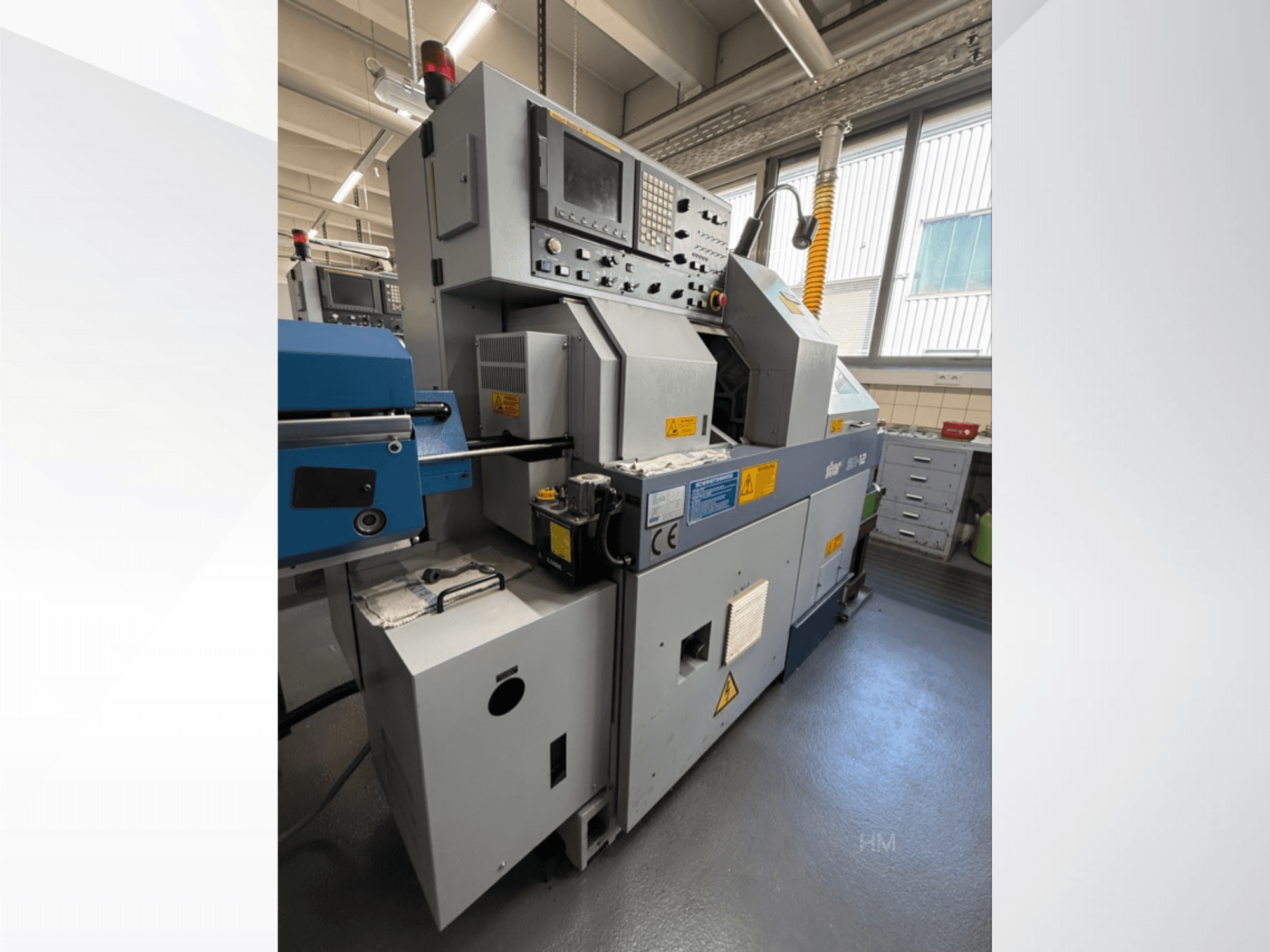 Vorderansicht des Geräts lithec 3231 mit Bedienfeld, Motor und blauem Einzugsbereich in einer gut beleuchteten Industrieumgebung.