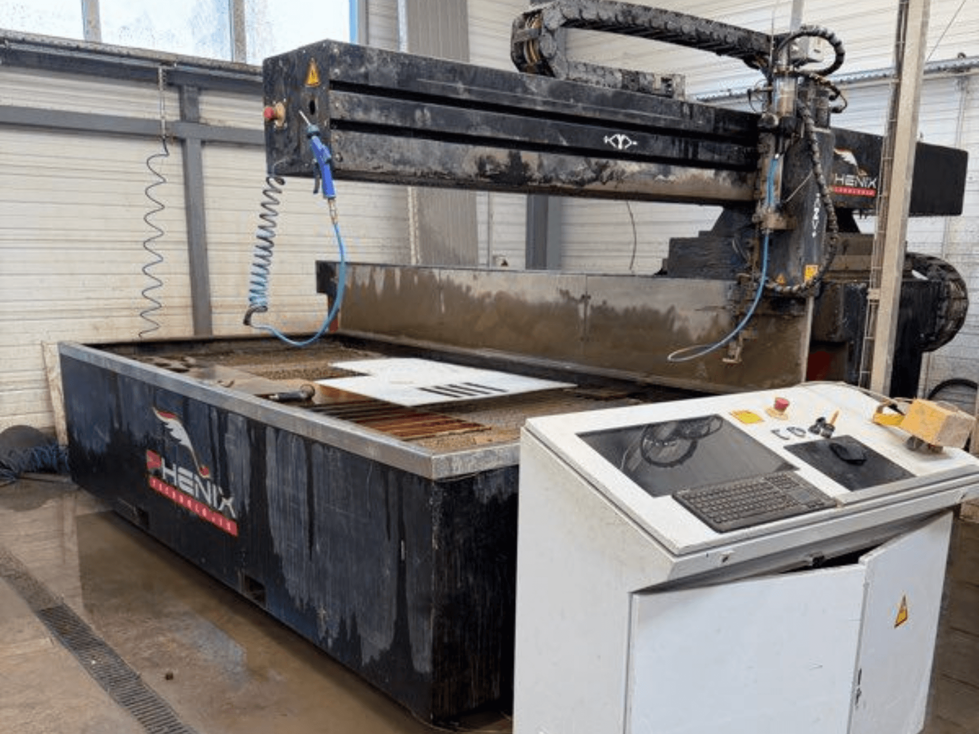 PHENIX MD JET 1530 Wasserstrahlschneidmaschine, Frontansicht mit Bedienfeld und Schneidbereich mit sichtbarem Wassertank.