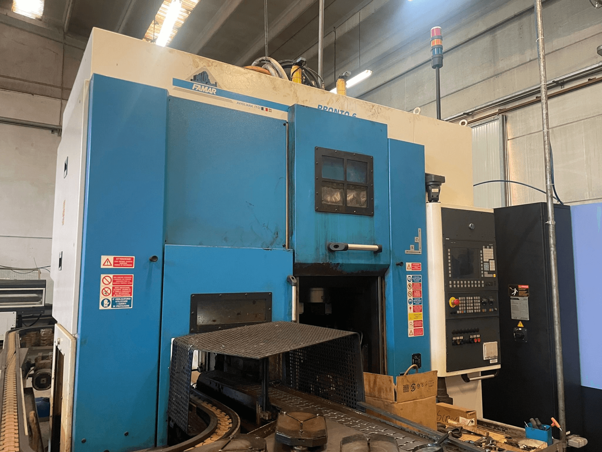 Famar Pronto 6 Vertikaldrehmaschine in einer Werkstatt, Seitenansicht, mit Bedienfeld, Betriebsfunktionen und Sicherheitsschildern.