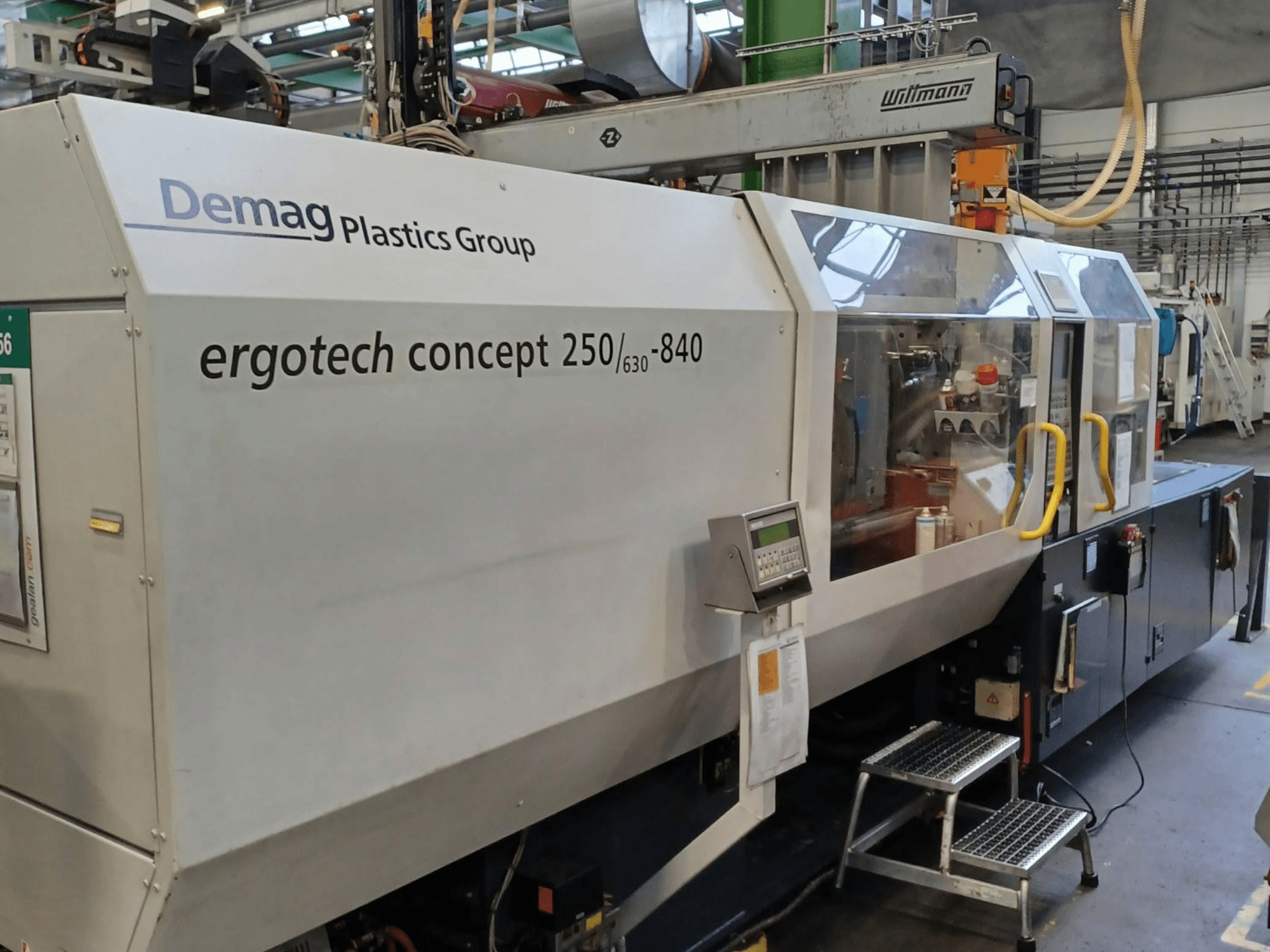 Demag ergotech concept 250/630-840 Spritzgießmaschine, Frontansicht, mit digitaler Steuerung und durchsichtigen Sicherheitsabdeckungen.