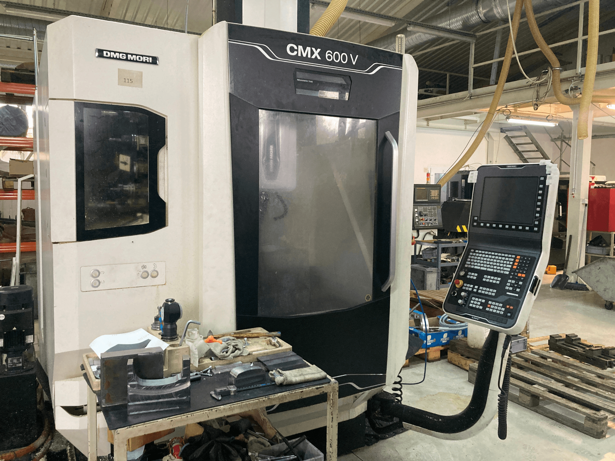 DMG MORI CMX 600 V Fräsmaschine von vorne gesehen, mit Blick auf das Bedienfeld und den Arbeitstisch mit Werkzeugen.