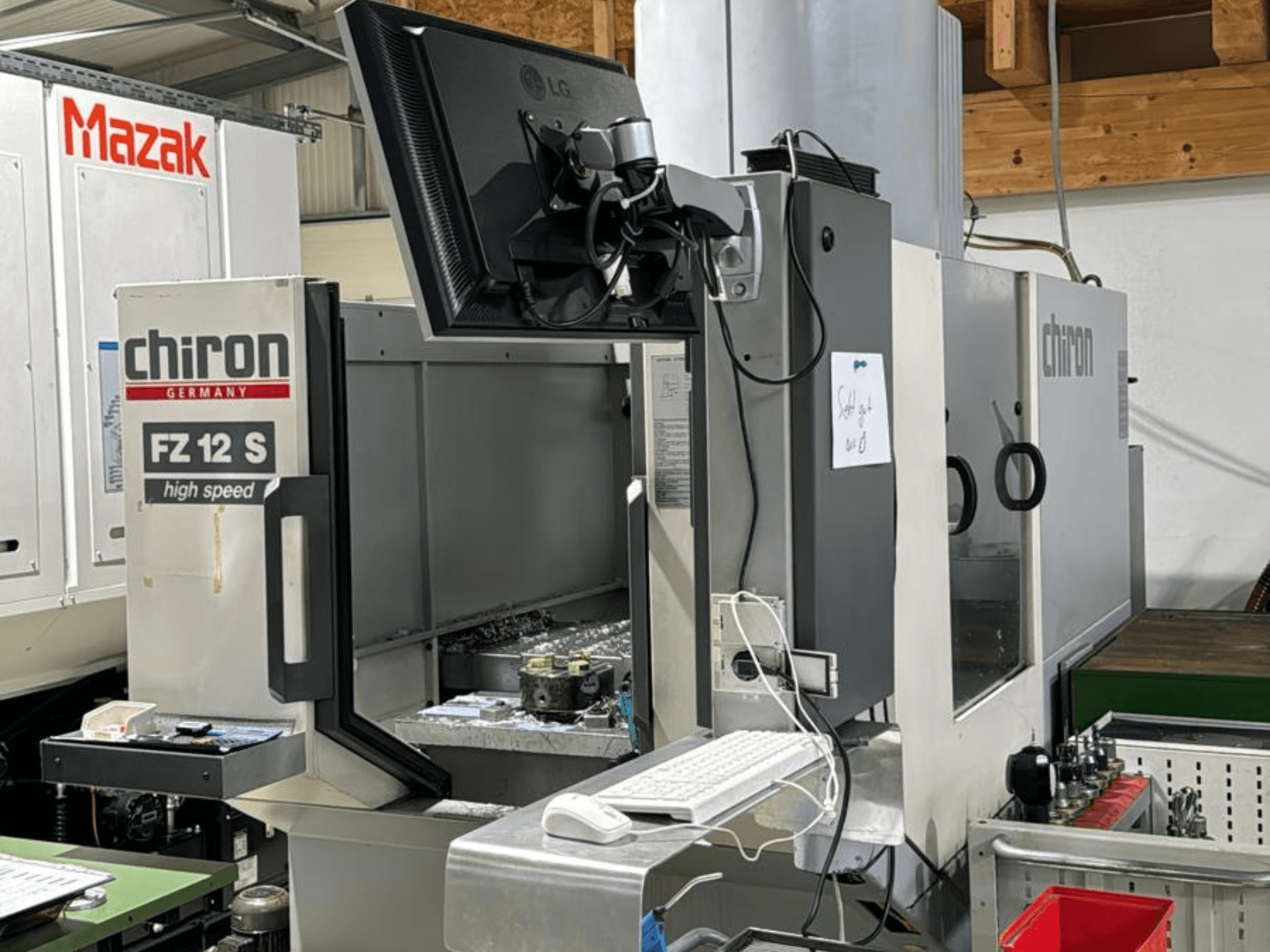Vertikale Ansicht des Hochgeschwindigkeits-Fertigungszentrums CHIRON FZ 12 S mit Kontrollbildschirm und Ablagerungen aus dem Bearbeitungsprozess.