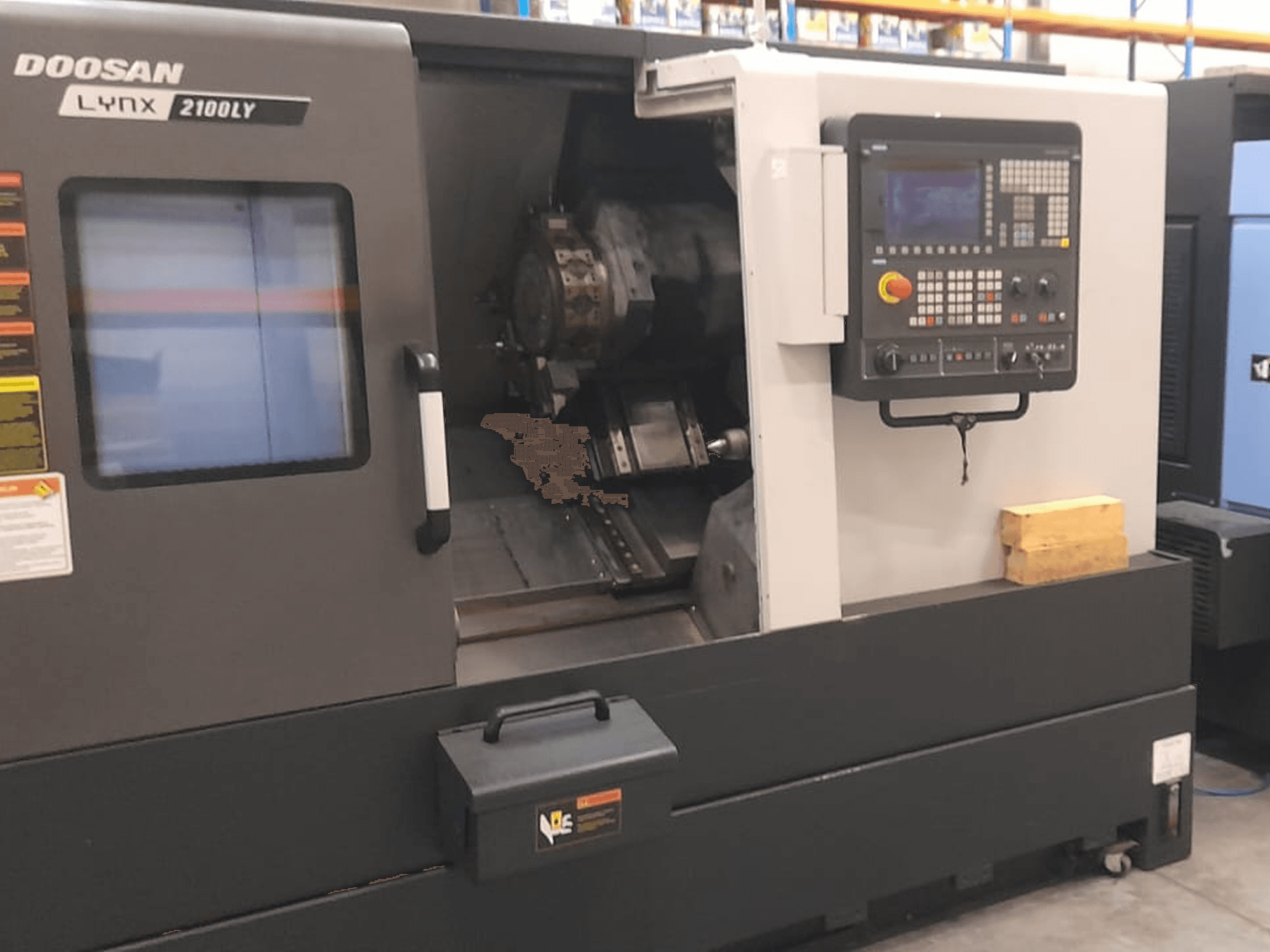 Doosan Lynx 2100LY CNC lathe, front view showing control panel, tool holder, and interior workspace; technical labels visible.