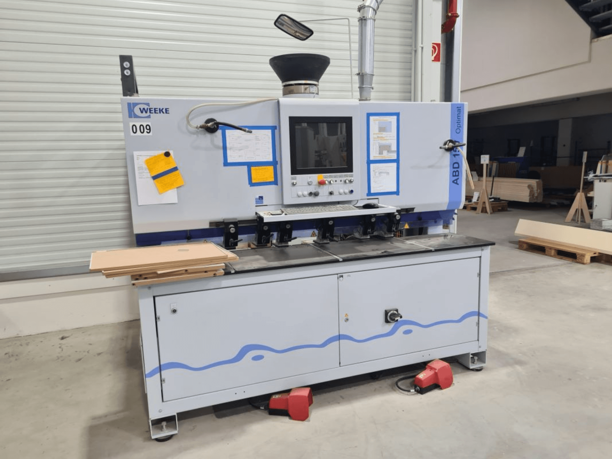 HOMAG WEEKE OPTIMAT ABD150 Mehrspindelbohrmaschine, Vorderansicht, mit Bedienelementen und gestapelten Holzplatten.