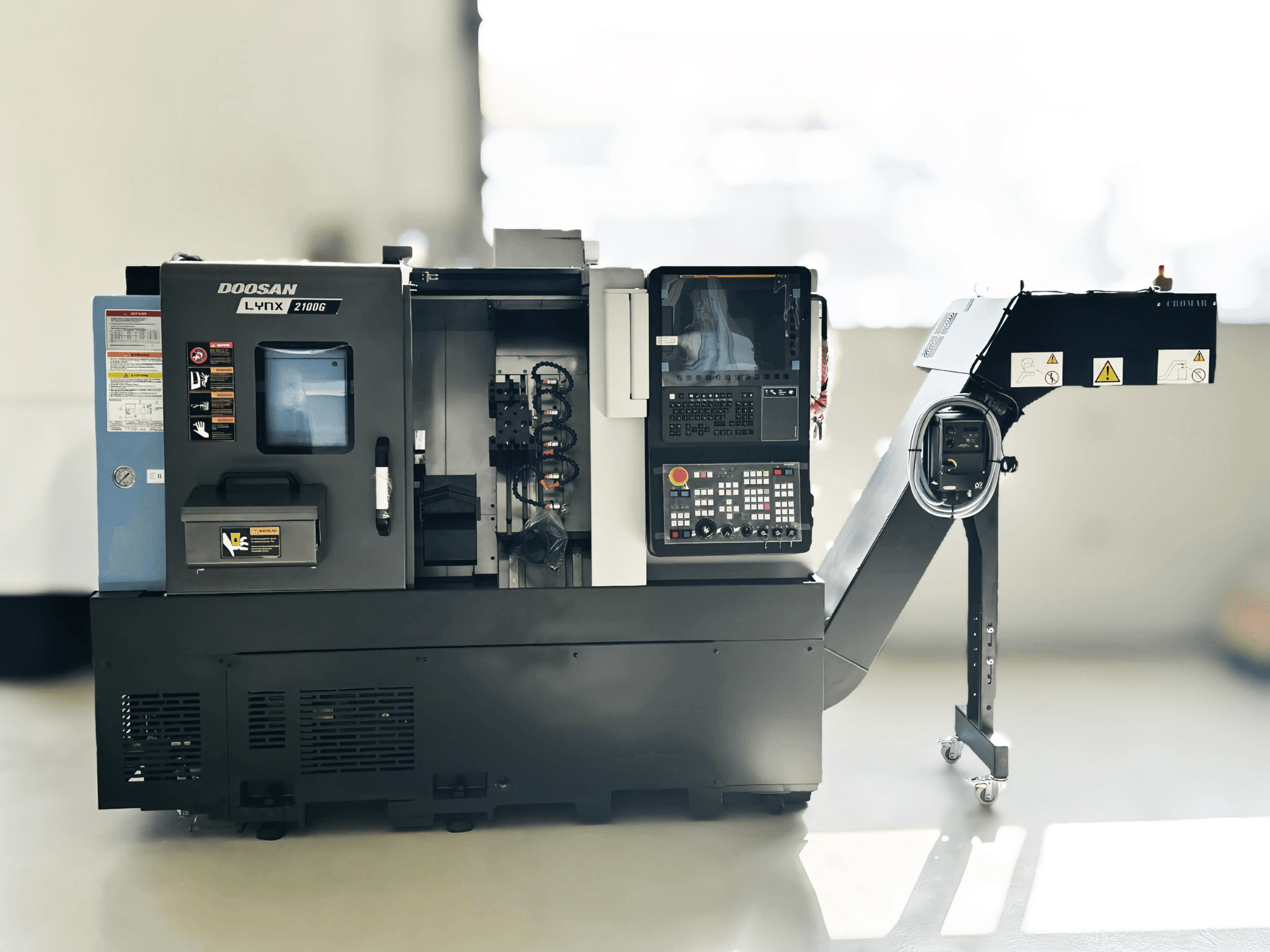 DOOSAN LYNX 2100GA Schweizer Drehmaschine in der Seitenansicht mit Bedienfeld und Werkzeughalter sichtbar.