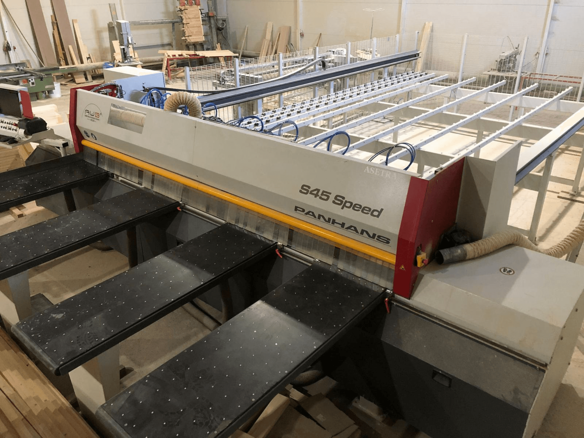 Seitenansicht einer PANHANS S45 Speed Plattensäge mit Fünf-Tisch-Aufstellung und sichtbarem Bedienpult mit Staubabsaugung.