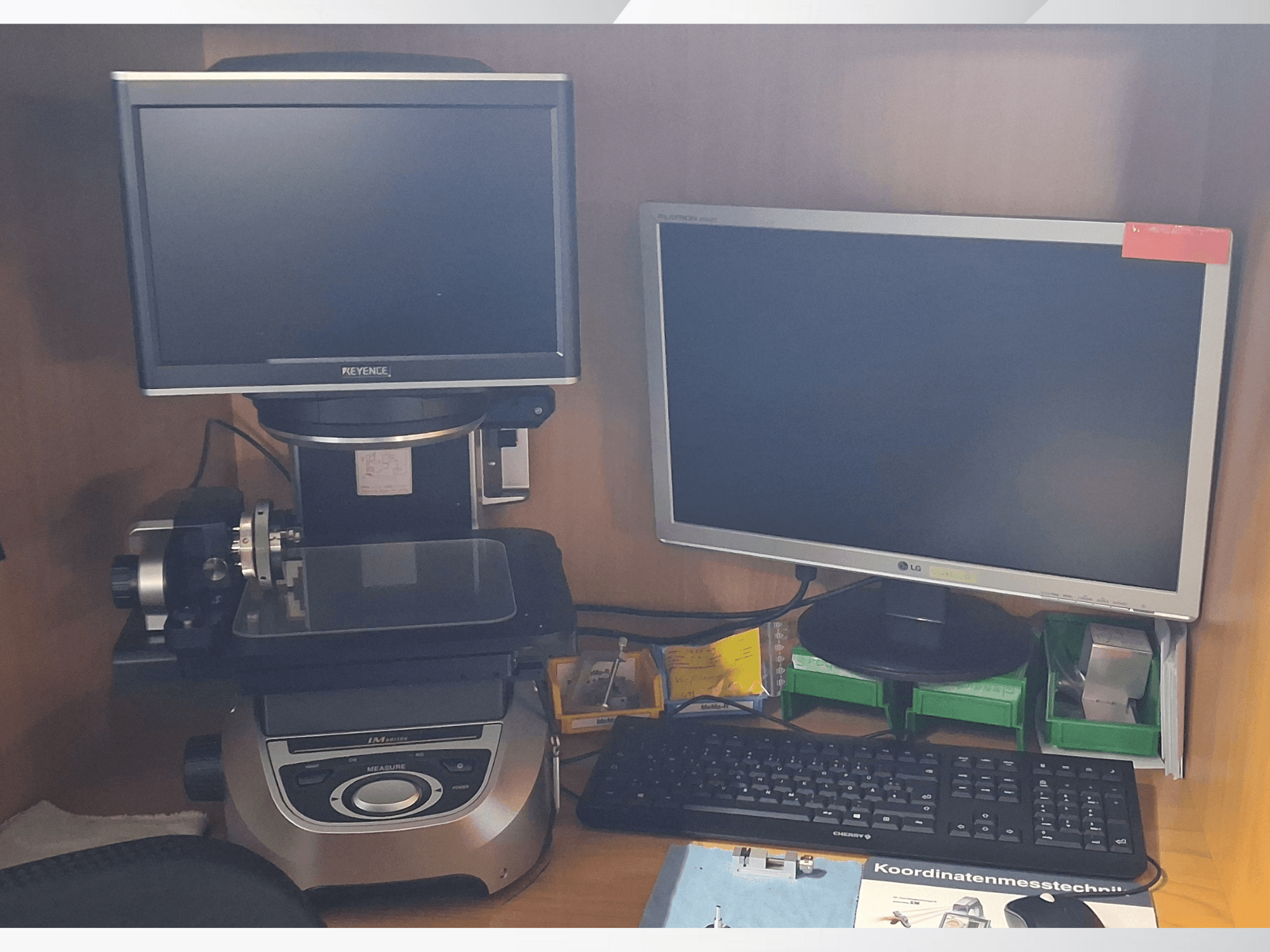 Keyence-Messsystem mit zwei Monitoren (ein LG, ein Keyence) und einer Tastatur, von vorne gesehen.