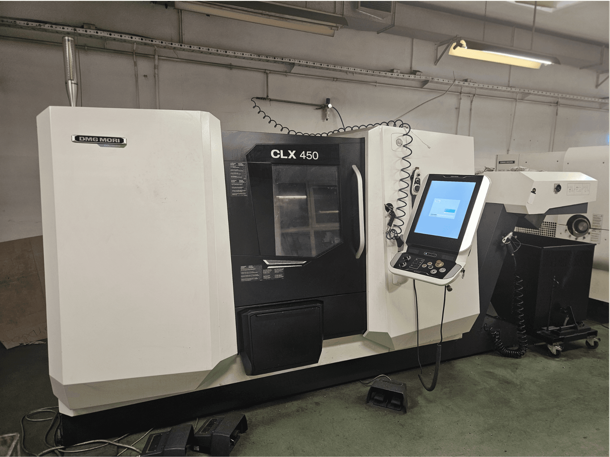 DMG MORI CLX 450 CNC-Maschine in der Frontansicht mit Bedienfeld und Touchscreen-Display in einer Werkstattumgebung.