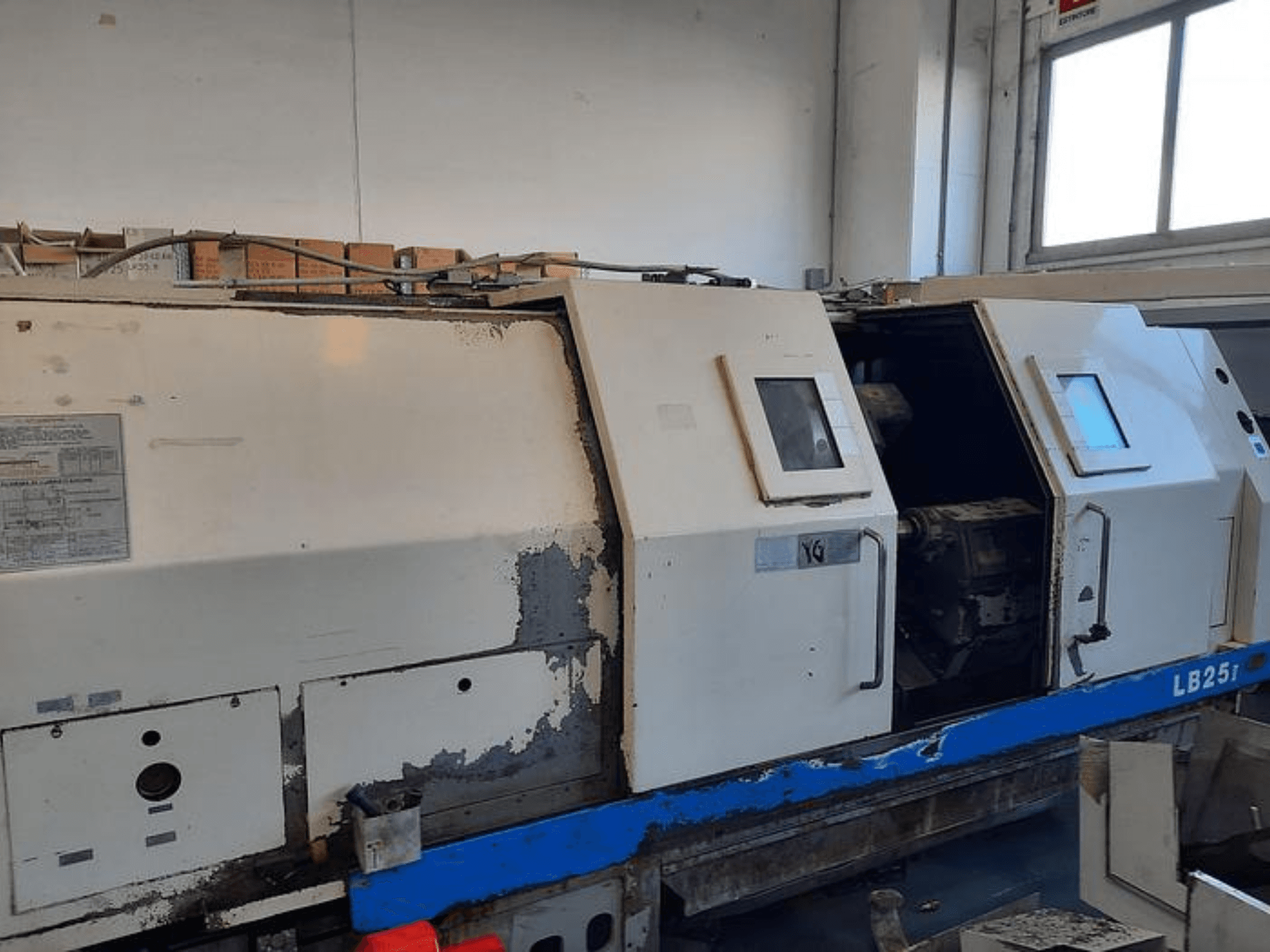 Used LB251 lathe machine, side view showing worn exterior, open panel revealing interior mechanism and operational controls.