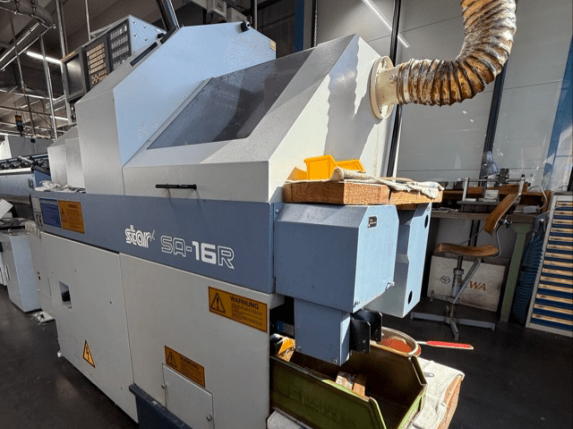 Stark SA-16R machine viewed from the front, featuring a tapered exhaust and workspace with yellow tools and warning labels.