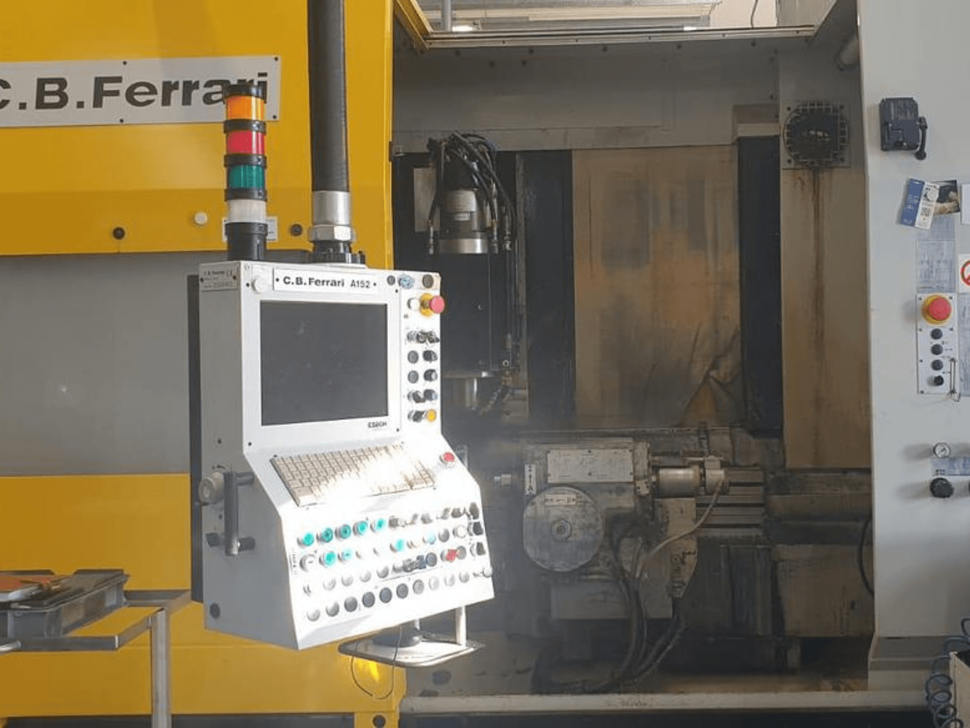 C.B. Ferrari A152 Vertikal-Bearbeitungszentrum in der Vorderansicht, mit Bedienfeld mit Tasten und Motorkomponenten an der Maschine.
