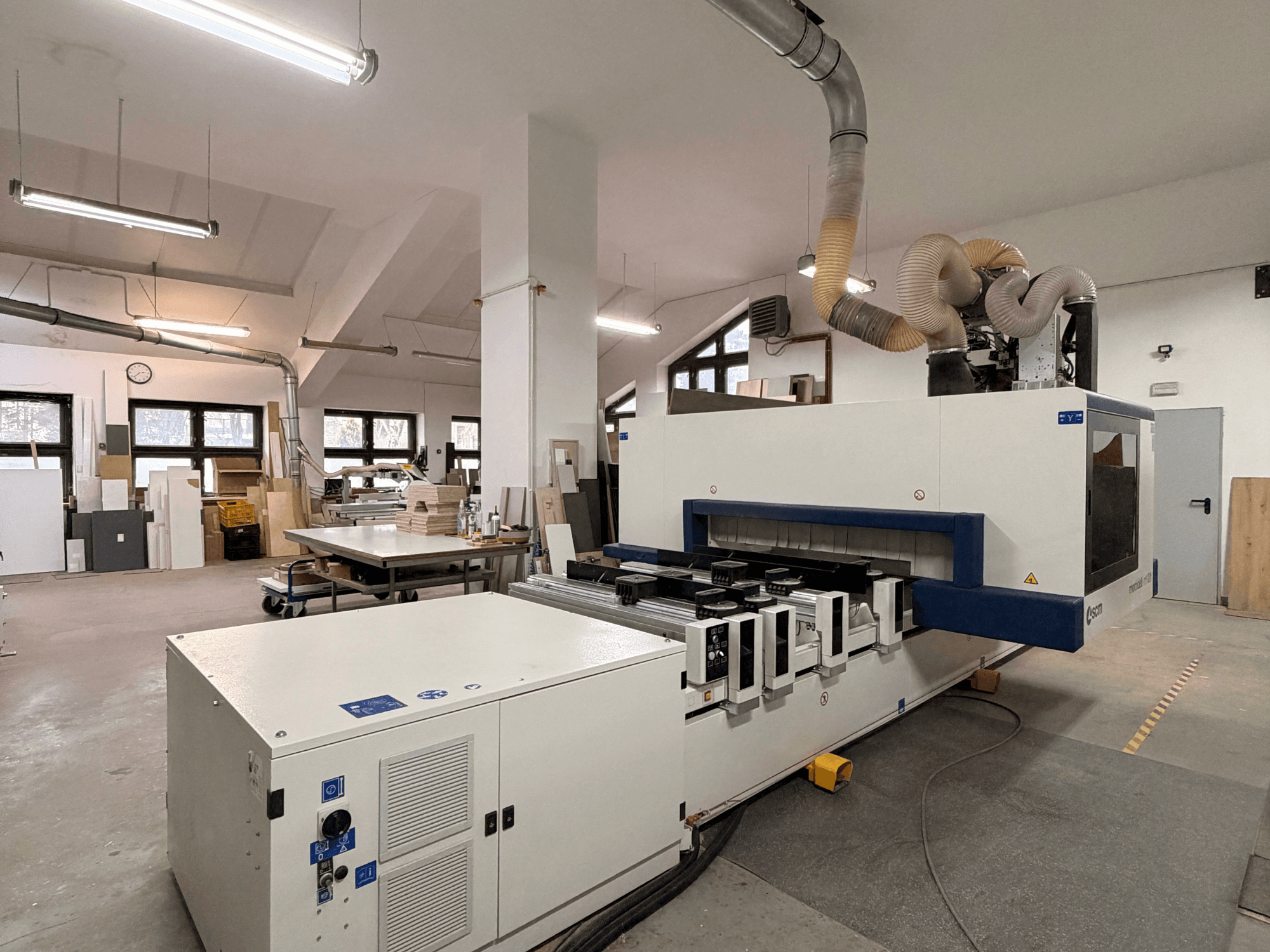 CNC-Holzbearbeitungszentrum SCM Morbidelli M100 von vorne gesehen, mit Bedienfeld und Absauganlage in der Werkstatt.