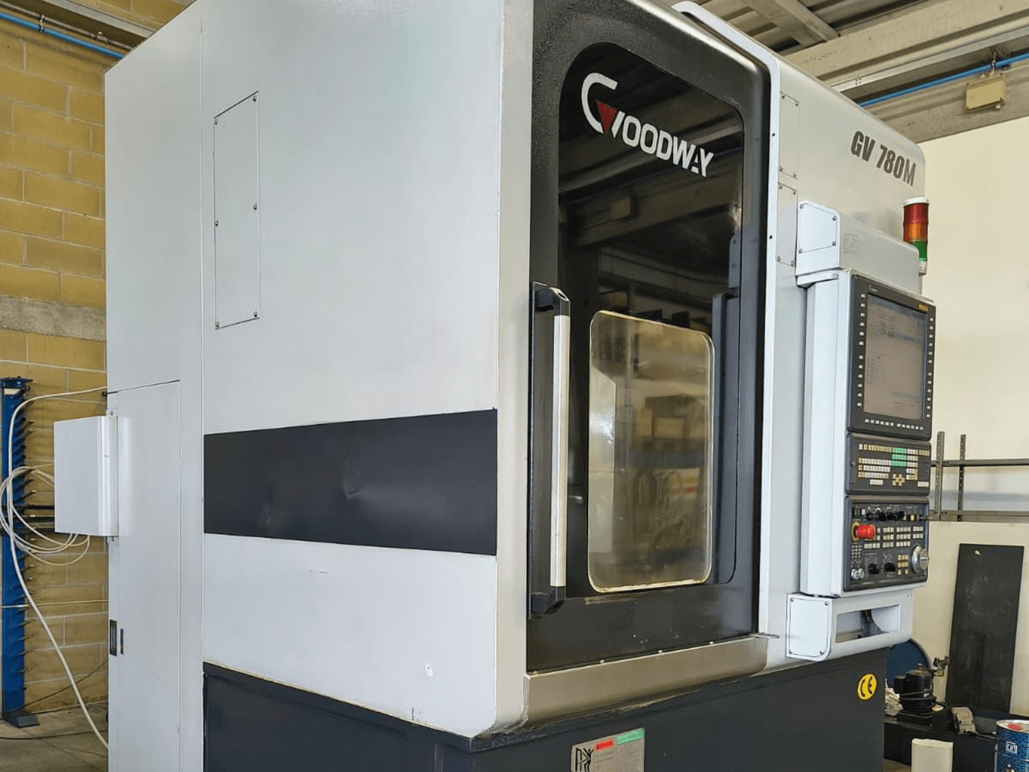 Goodway GV 780 M Vertikaldrehmaschine, Seitenansicht, mit Bedienfeld, Sicherheitsfunktionen und sauberem Außendesign.