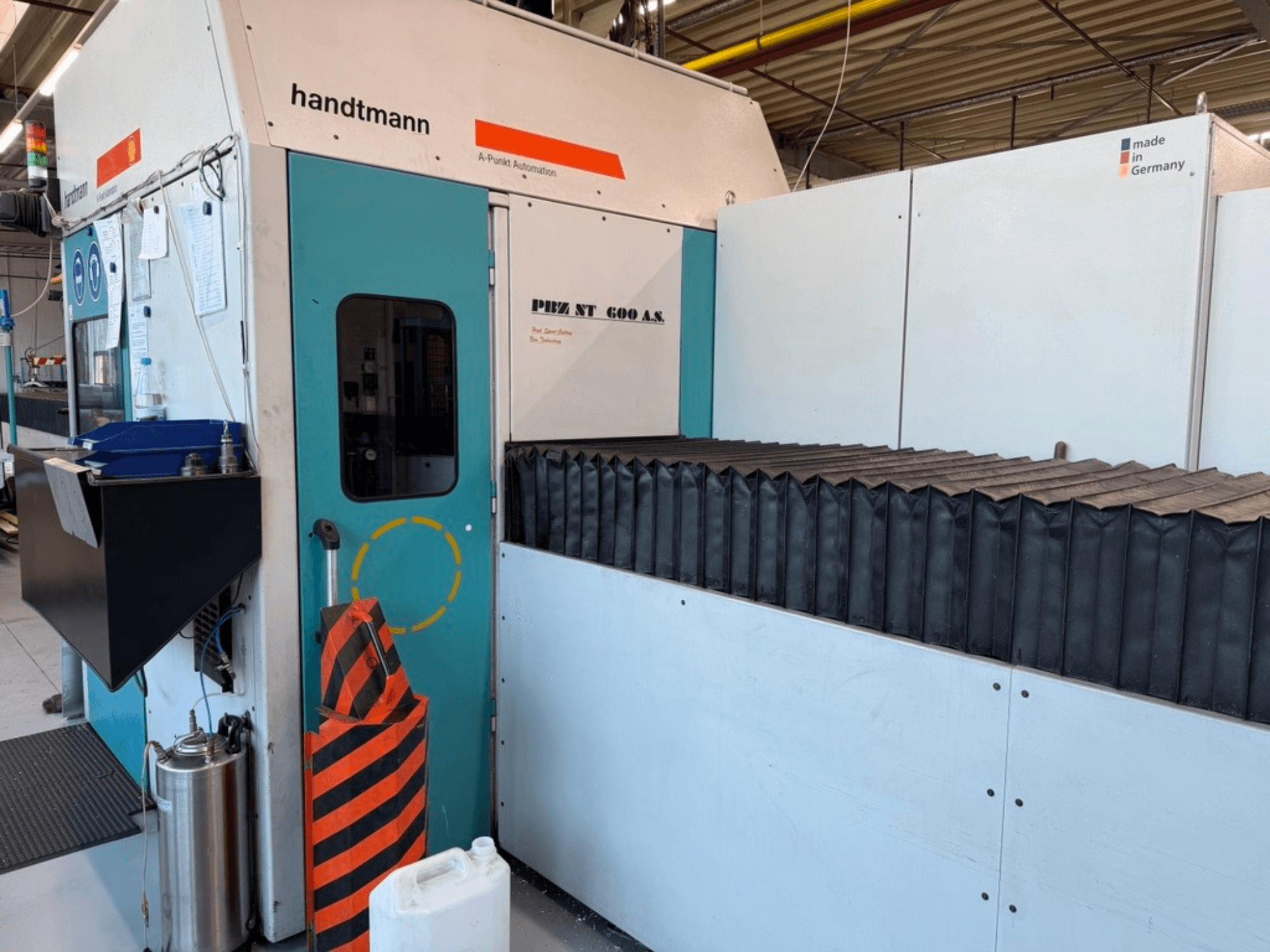 Frontansicht der Handtmann Portalfräsmaschine PBZ NT 600 AS mit dunkler Arbeitsfläche und Sicherheitsschranken.