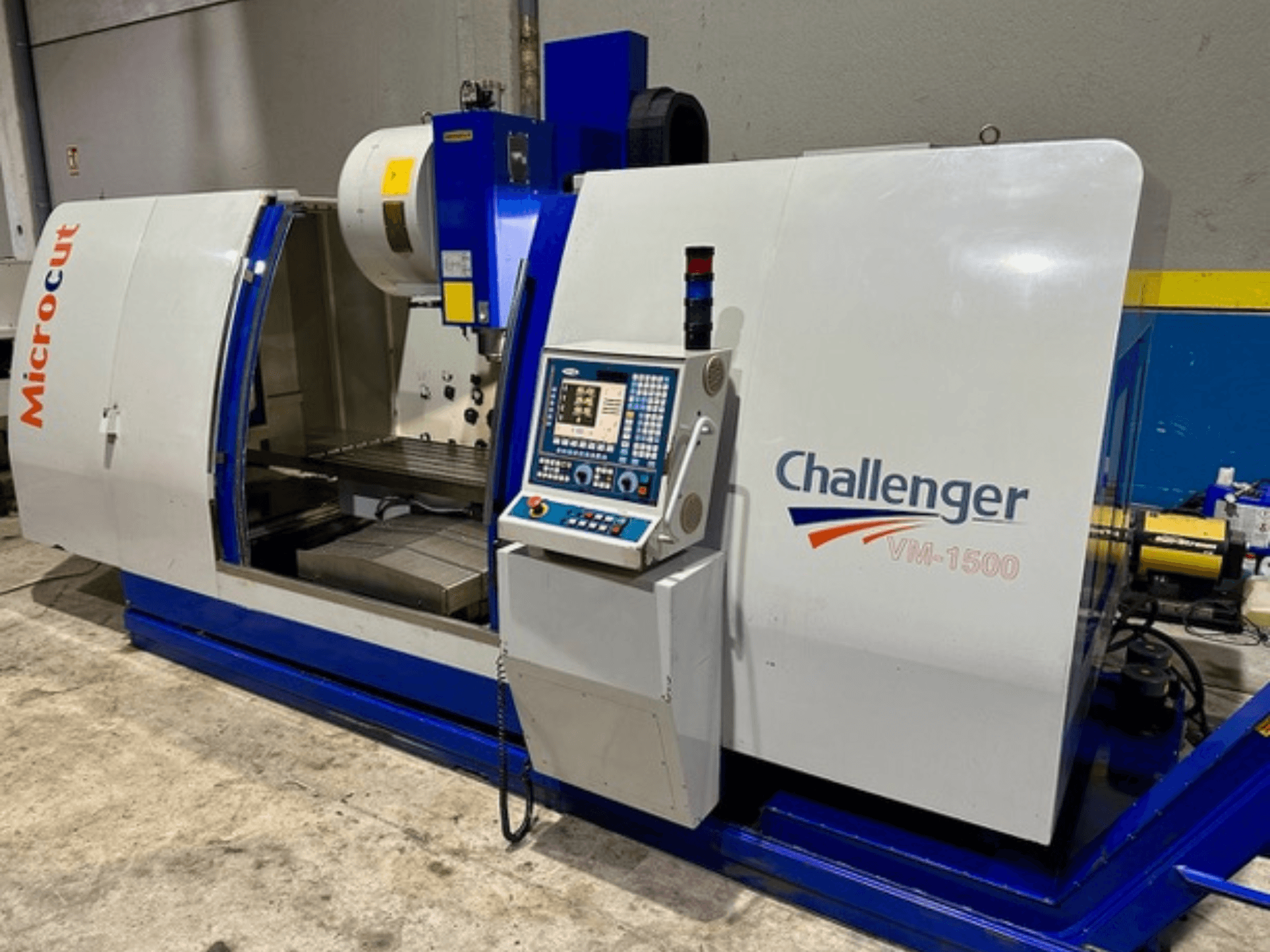 Microcut Challenger VM-1500 CNC-Maschine, Vorderansicht, mit Bedienfeld, Arbeitsbereich und blauem Sockel.