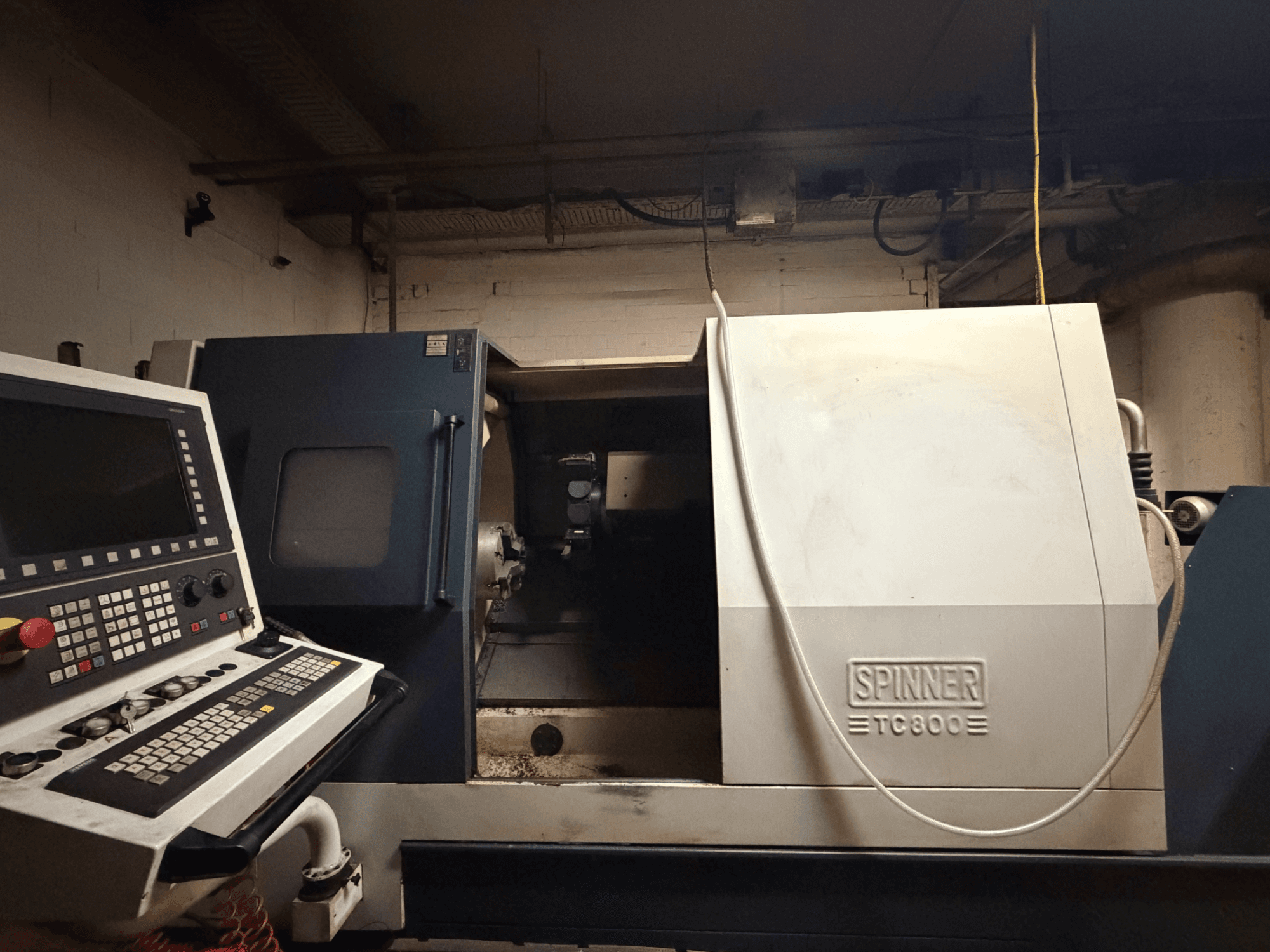 Horizontal-Drehmaschine SPINNER TC800, Vorderansicht mit sichtbarem Bedienfeld und leicht freigelegtem Maschineninneren.