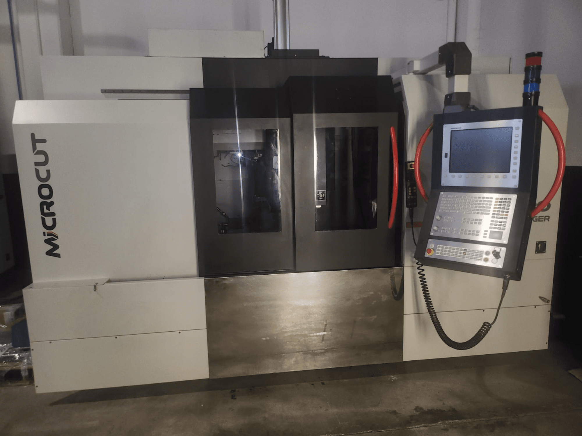 Microcut CNC machine viewed from the front; features control panel, dual windows, industrial design, and metallic finish.