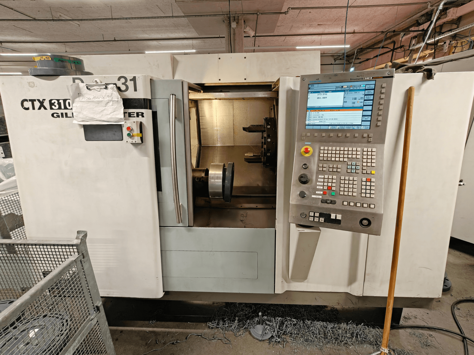 Gildemeister CTX 310 Horizontal-Drehmaschine, Vorderansicht mit Bedienfeld, mit Werkzeugen und Arbeitsraum im Inneren.