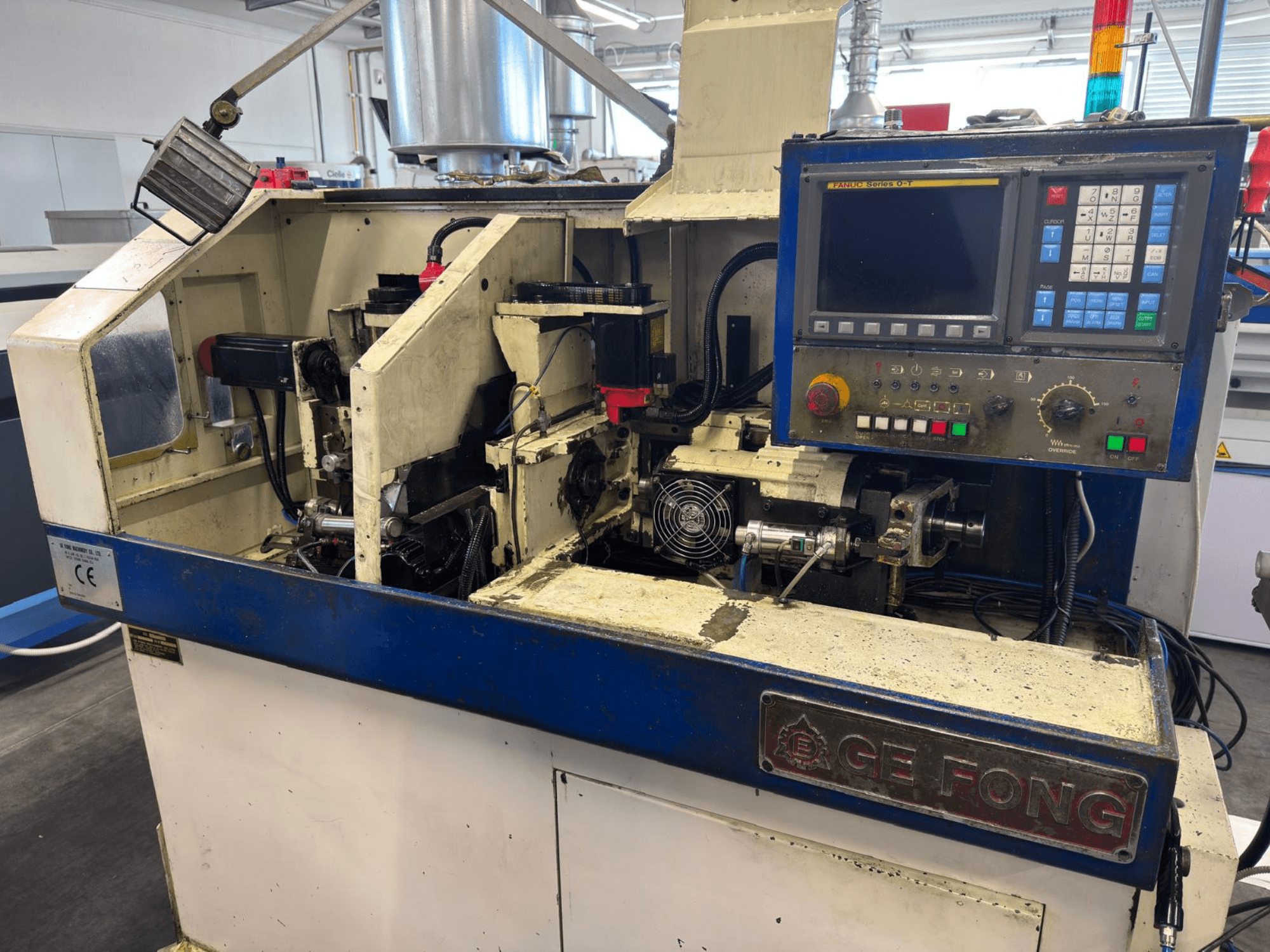 GE FONG-Industriemaschine in der Vorderansicht, mit internen Komponenten, Bedienfeld und Betriebsteilen.