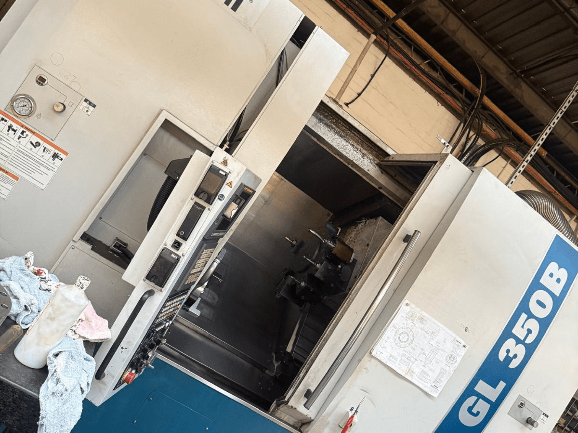 Horizontal-Drehmaschine Romi GL 350B, Vorderansicht, mit Bedienfeld und geöffneter Tür, die das Innere der Maschine zeigt.