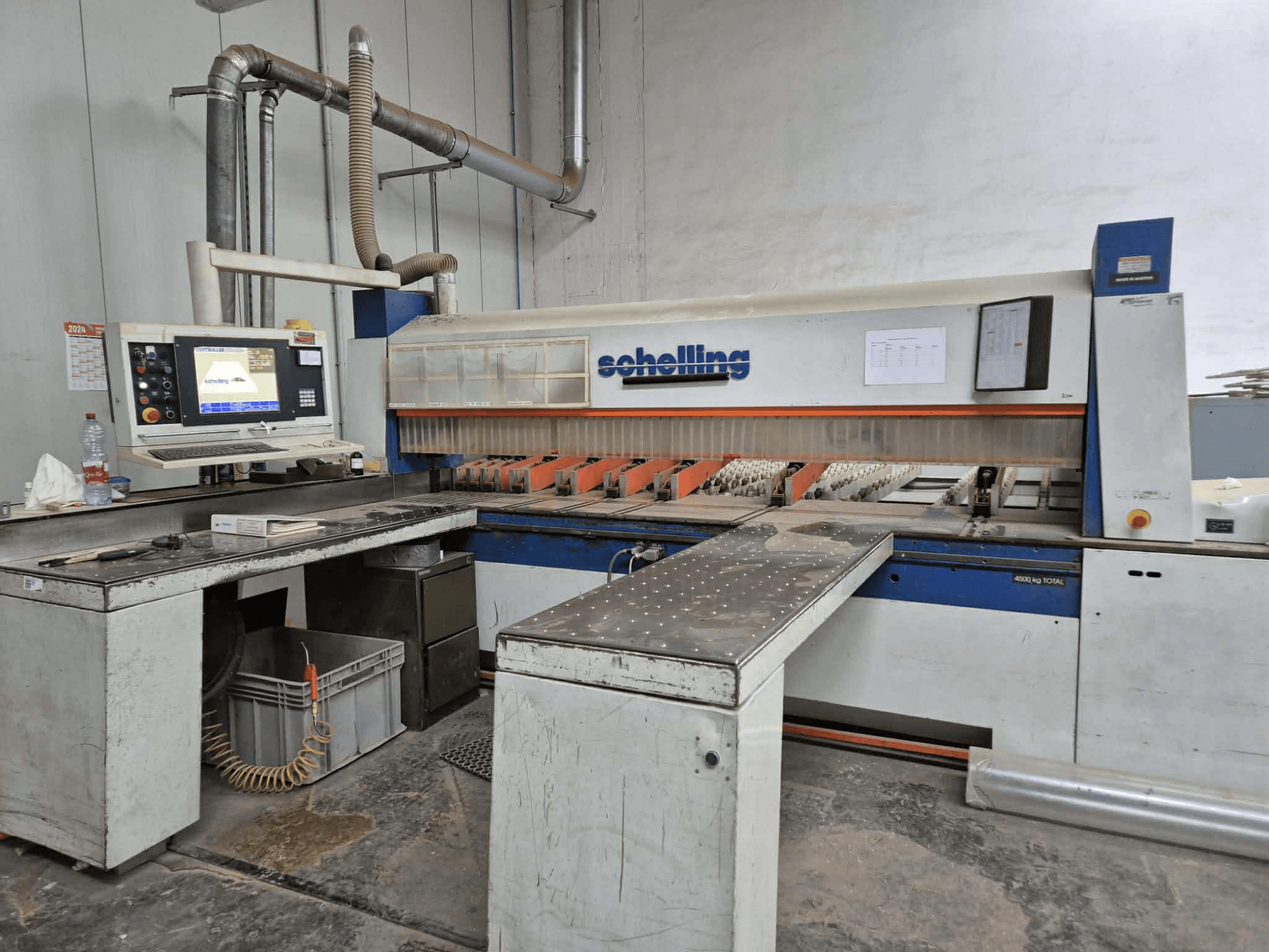 Schaublin-Schneidemaschine in der Seitenansicht, mit Computerschnittstelle, scharfen Klingen und einer stabilen Metallarbeitsfläche.