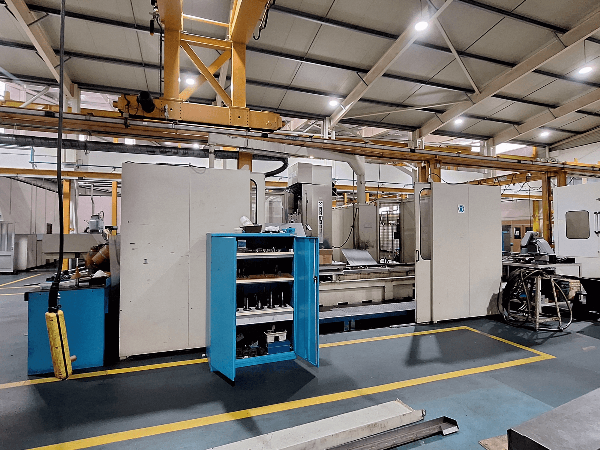 Portalfräsmaschine Rambaudi RX 1250, Vorderansicht mit Werkzeugspeicher, in einem großzügigen industriellen Arbeitsraum.
