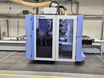 HOMAG BMG 512 ProfiLine CNC-Maschine, Frontansicht, mit Glasscheibe, sichtbaren Präzisionswerkzeugen und Industrieumgebung.