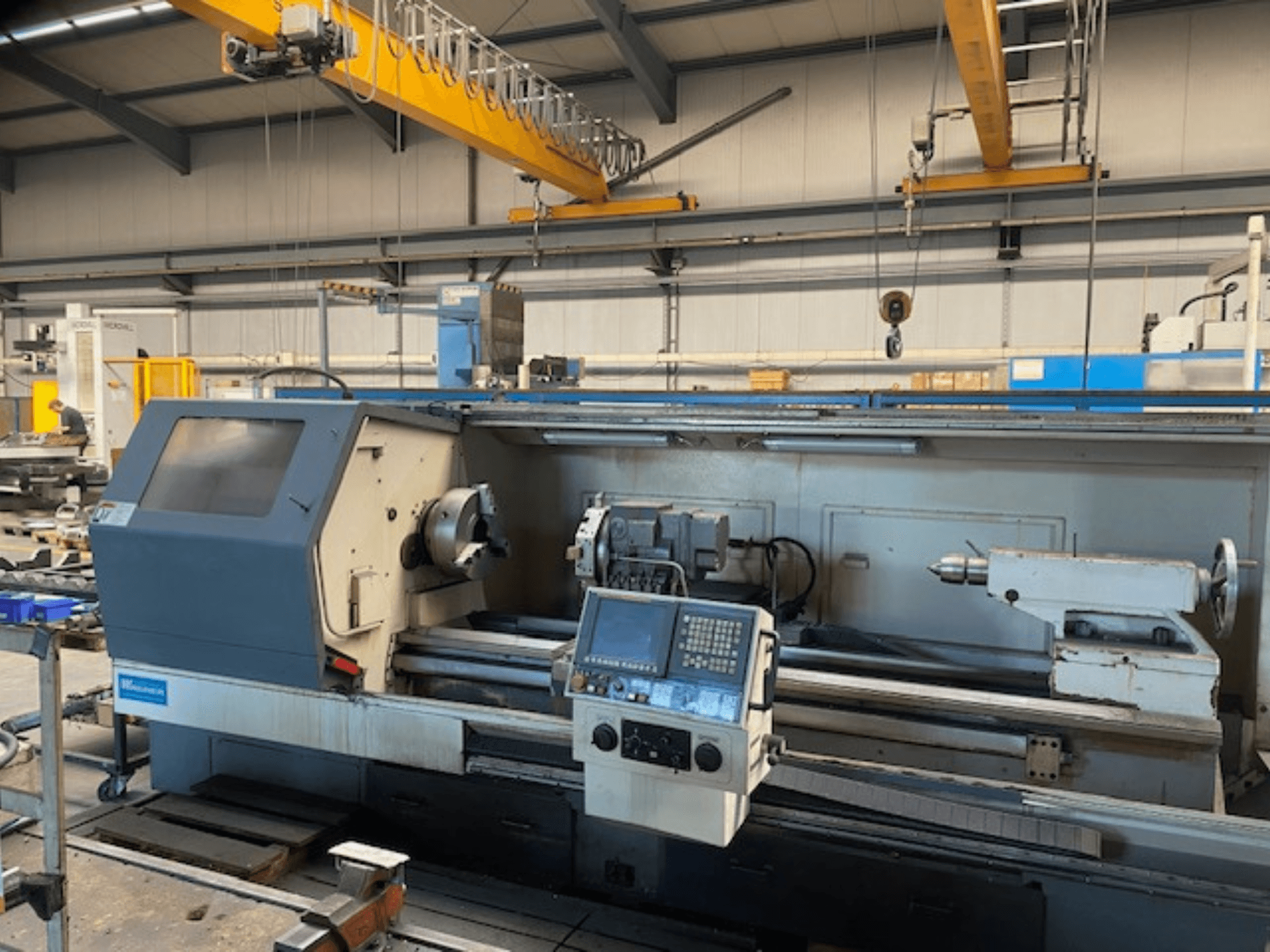 Wabeco-Präzisionsdrehmaschine, Vorderansicht mit Bedienfeld, zeigt die Spindel- und Werkzeugaufbauten in einer Werksumgebung.