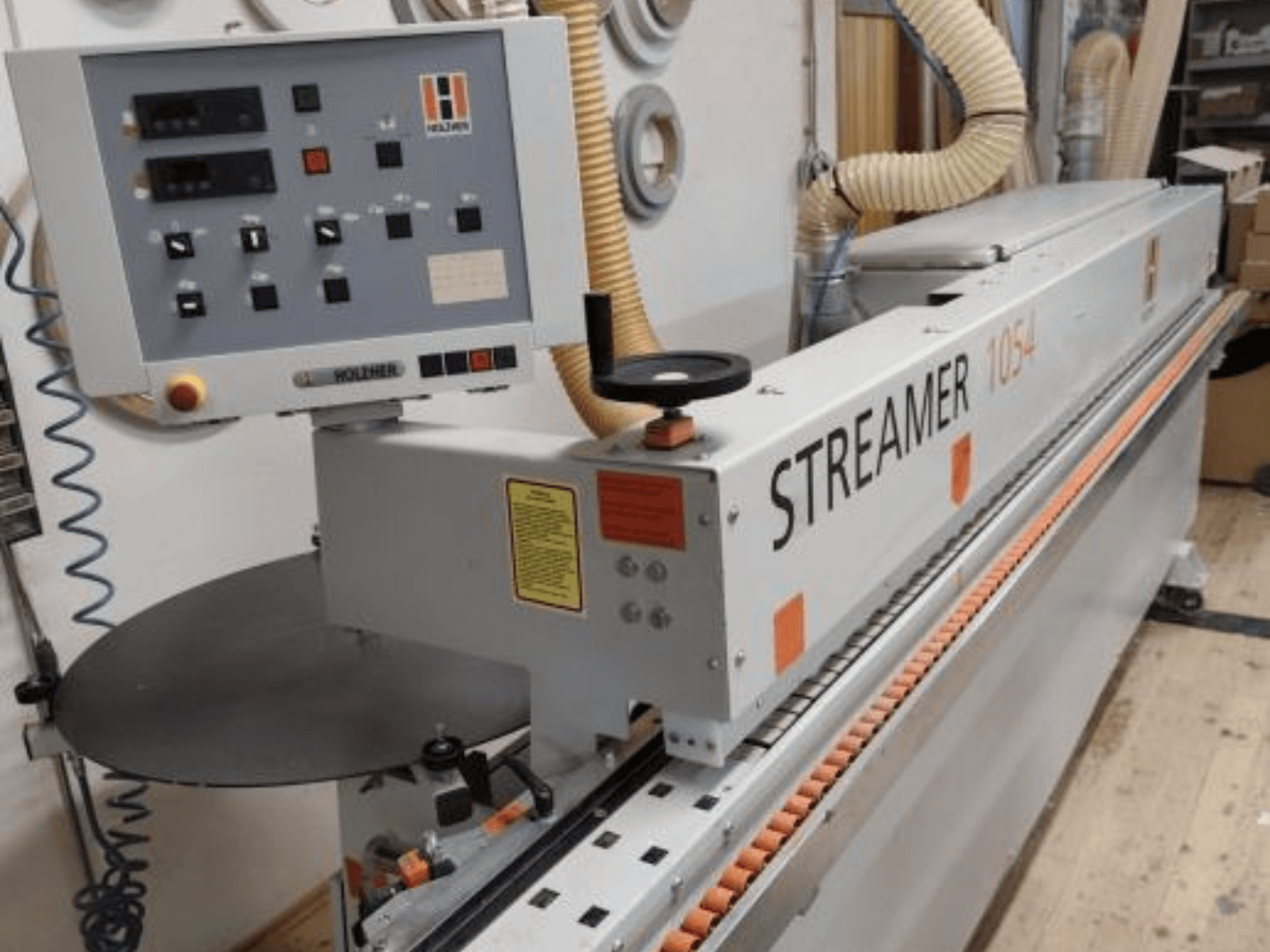 HOLZHER Streamer 1054 Kantenanleimmaschine, Seitenansicht mit Bedienfeld und Vorschubsystem vor einem Werkstatthintergrund.