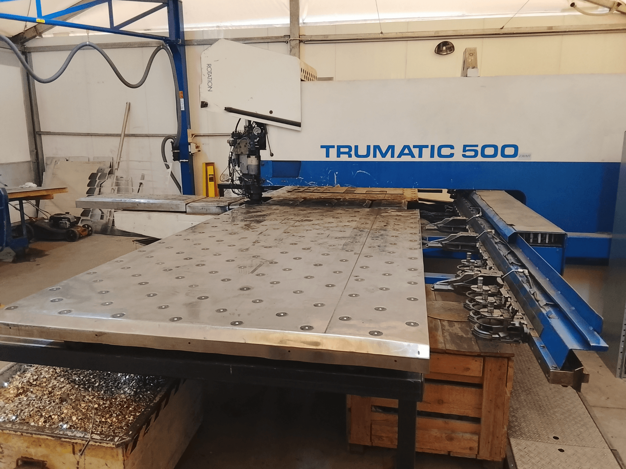 CNC-Maschine Trumatic 500, Draufsicht, mit einem großen Metallschneidetisch, unter dem Werkzeuge und Späne montiert sind.