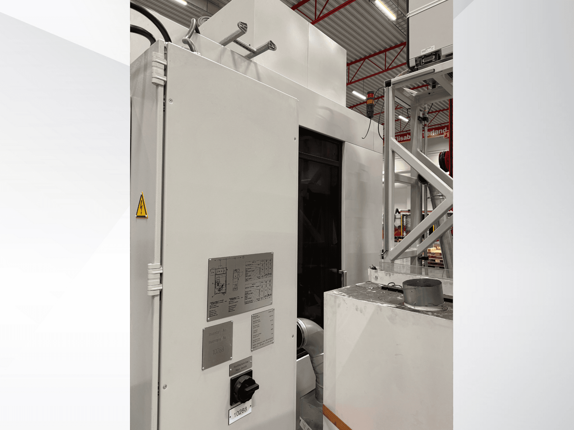 Seitenansicht einer weißen Industriemaschine mit Bedienfeld und Warnschild, Teil eines automatisierten Systems.