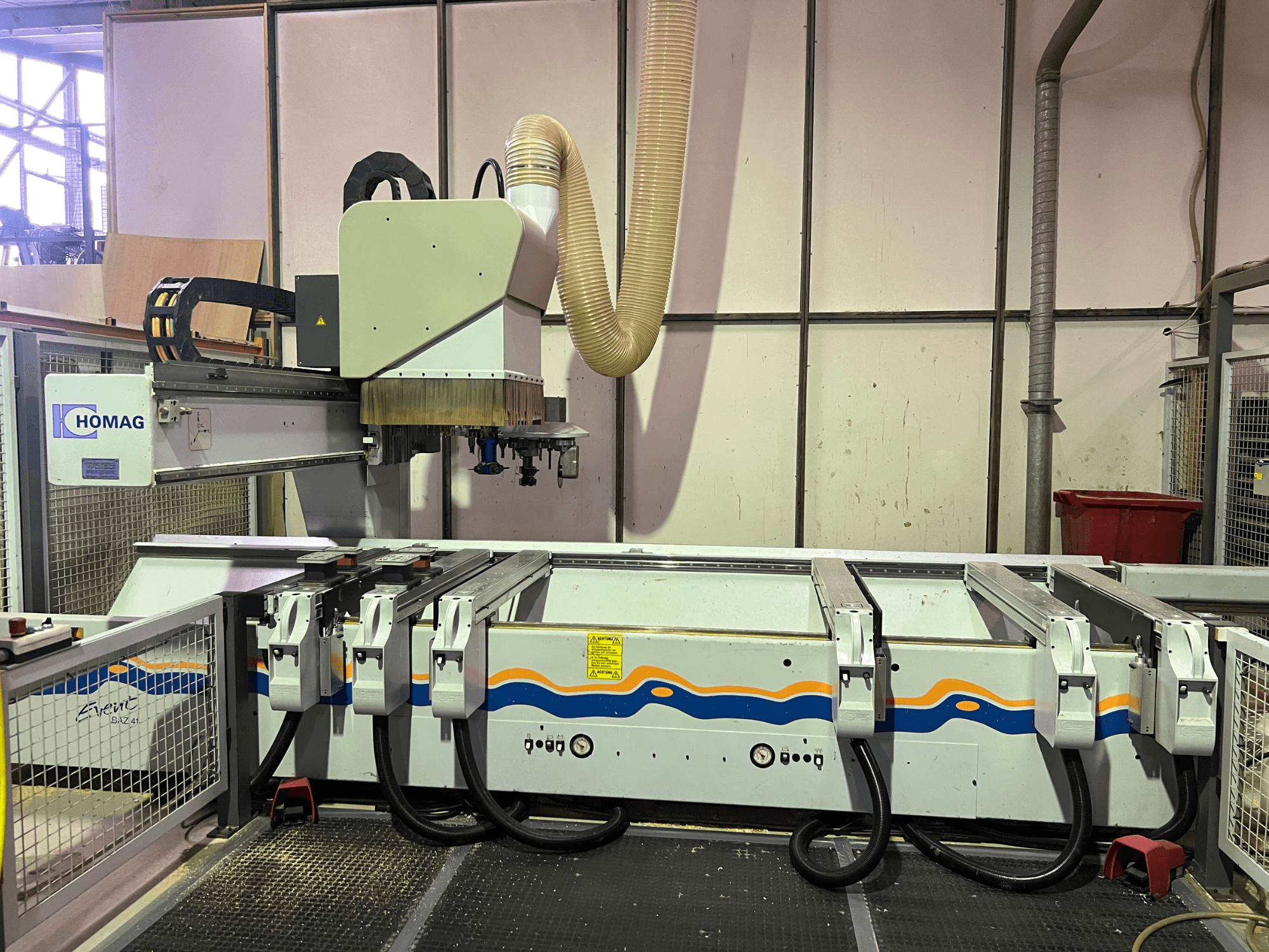 HOMAG BIZ 4 CNC-Maschine in der Werkstatt; Vorderansicht mit Staubabsaugung und Bedienfeld mit Kabeln.