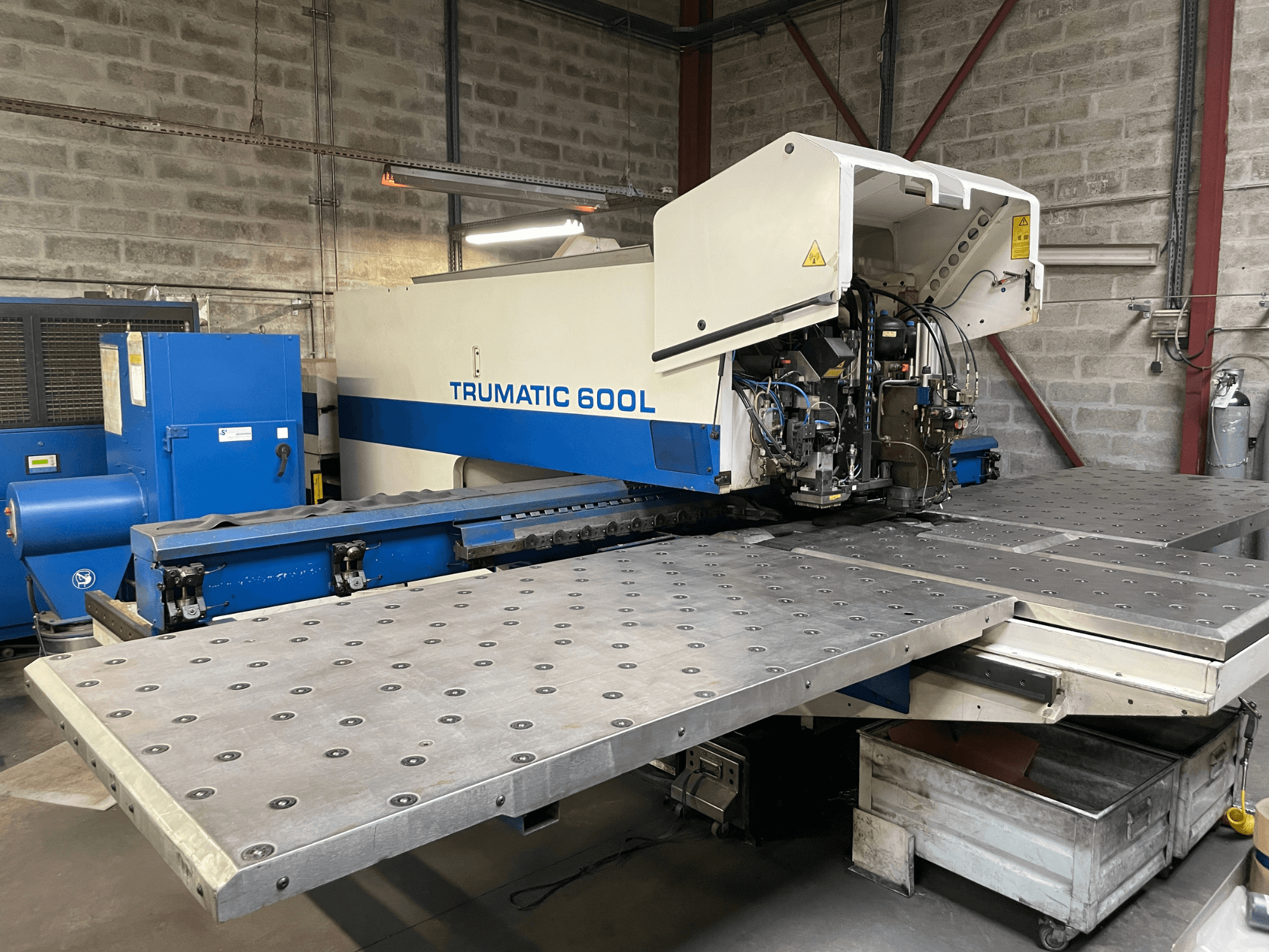CO2-Laserschneidanlage TRUMPF TRUMATIC TC 600L, Frontansicht mit Metallschneidetisch und Bedienfeld sichtbar.