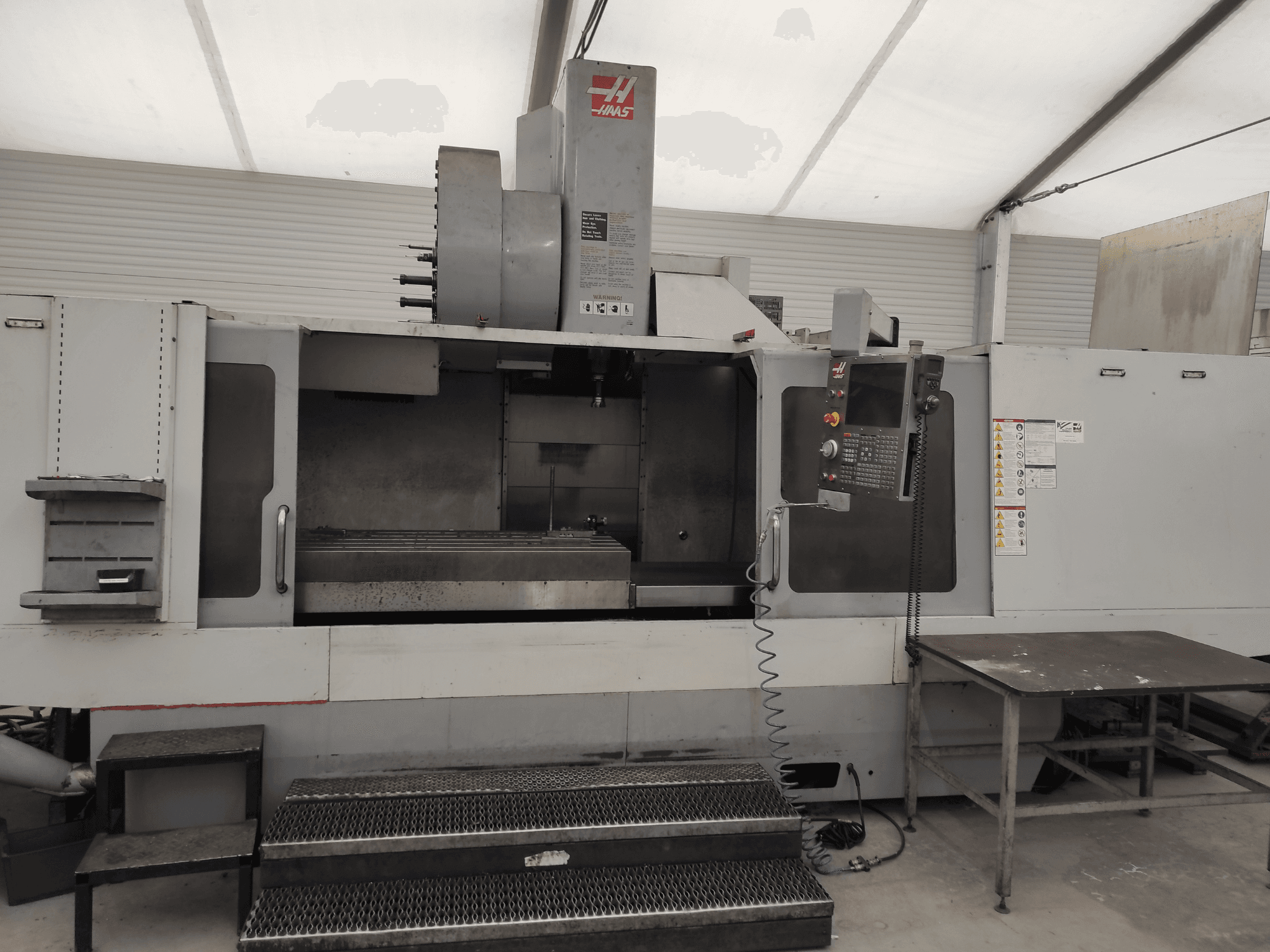 HAAS VF-10/50HE Vertikal-Bearbeitungszentrum, Vorderansicht mit Bedienpult, Maschinenbett und begehbarem Trittbrett zur Bedienung.