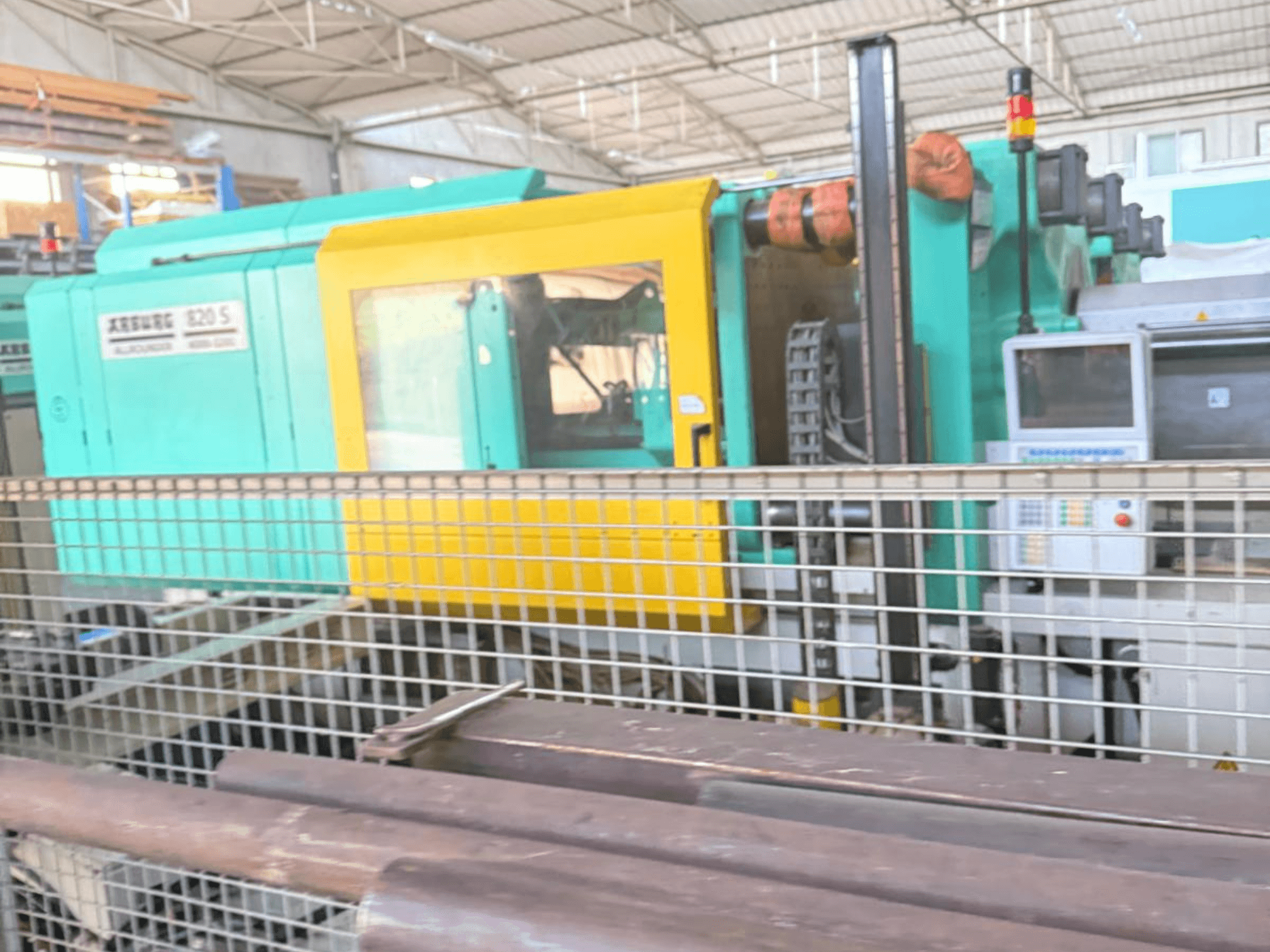 Hydraulische Spritzgießmaschine Arburg SELECTA 820 S 4000-3200, Seitenansicht, mit Bedienpult und leuchtend gelb-grünem Design.