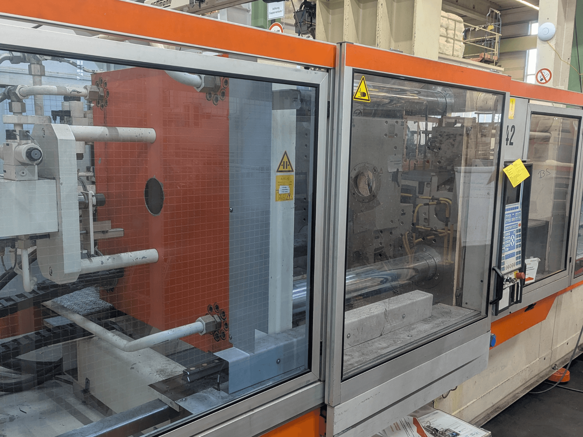 Frontansicht einer hydraulischen Spritzgießmaschine DEMAG SYSTEC 80/420-310 mit sichtbarem Bedienfeld und Maschinenkomponenten.