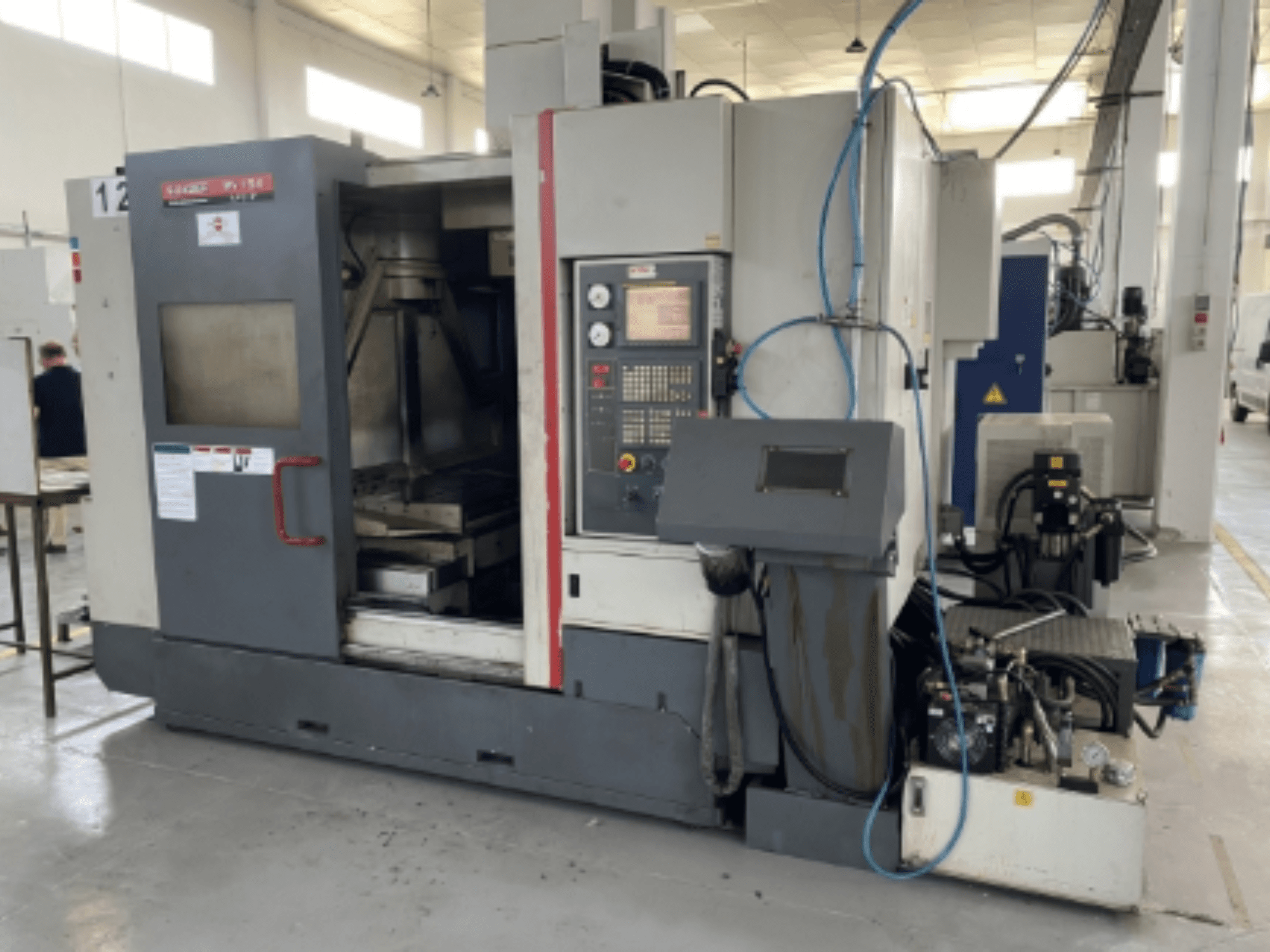 Quaser MV154APC-912 vertikales Bearbeitungszentrum, Vorderansicht mit Bedienfeld, geöffneter Tür und Maschinenkomponenten.