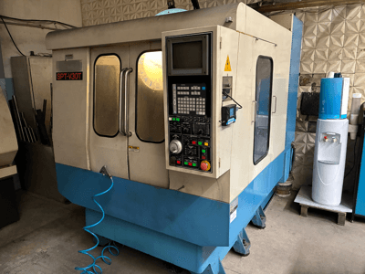 SPT-V30T CNC-Maschine in Blau und Weiß, Vorderansicht mit Bedienfeld, Türen und Luftschlauch. Perfekt für die Präzisionsbearbeitung.