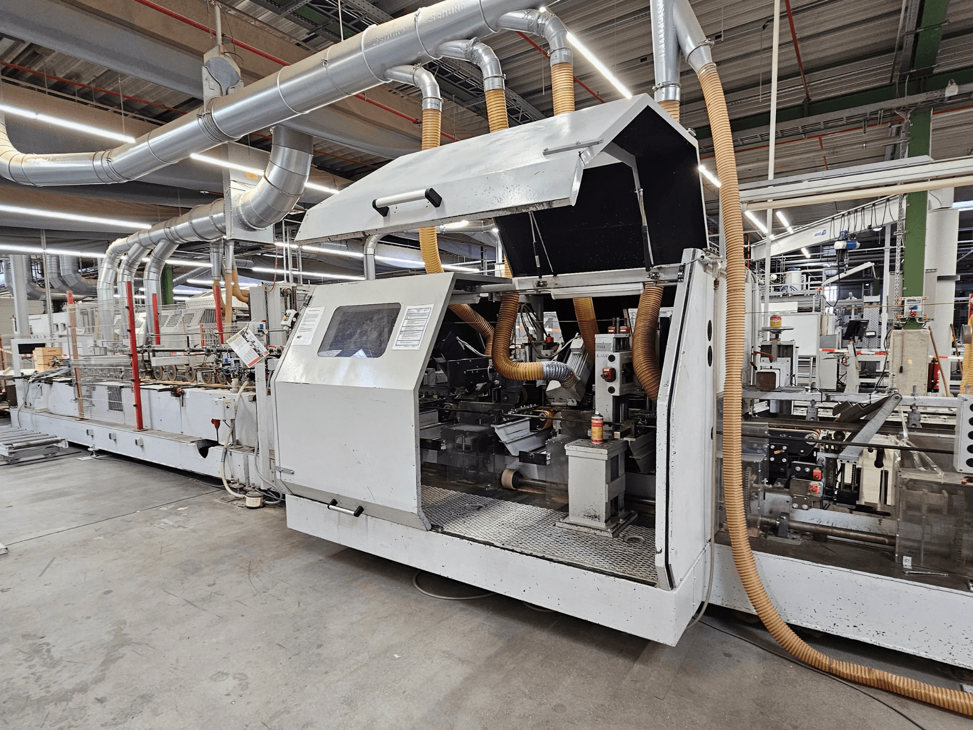 HOMAG FG63 Kantenanleimmaschine in Werkseinstellung, Seitenansicht mit Betriebskomponenten und Absaugung.