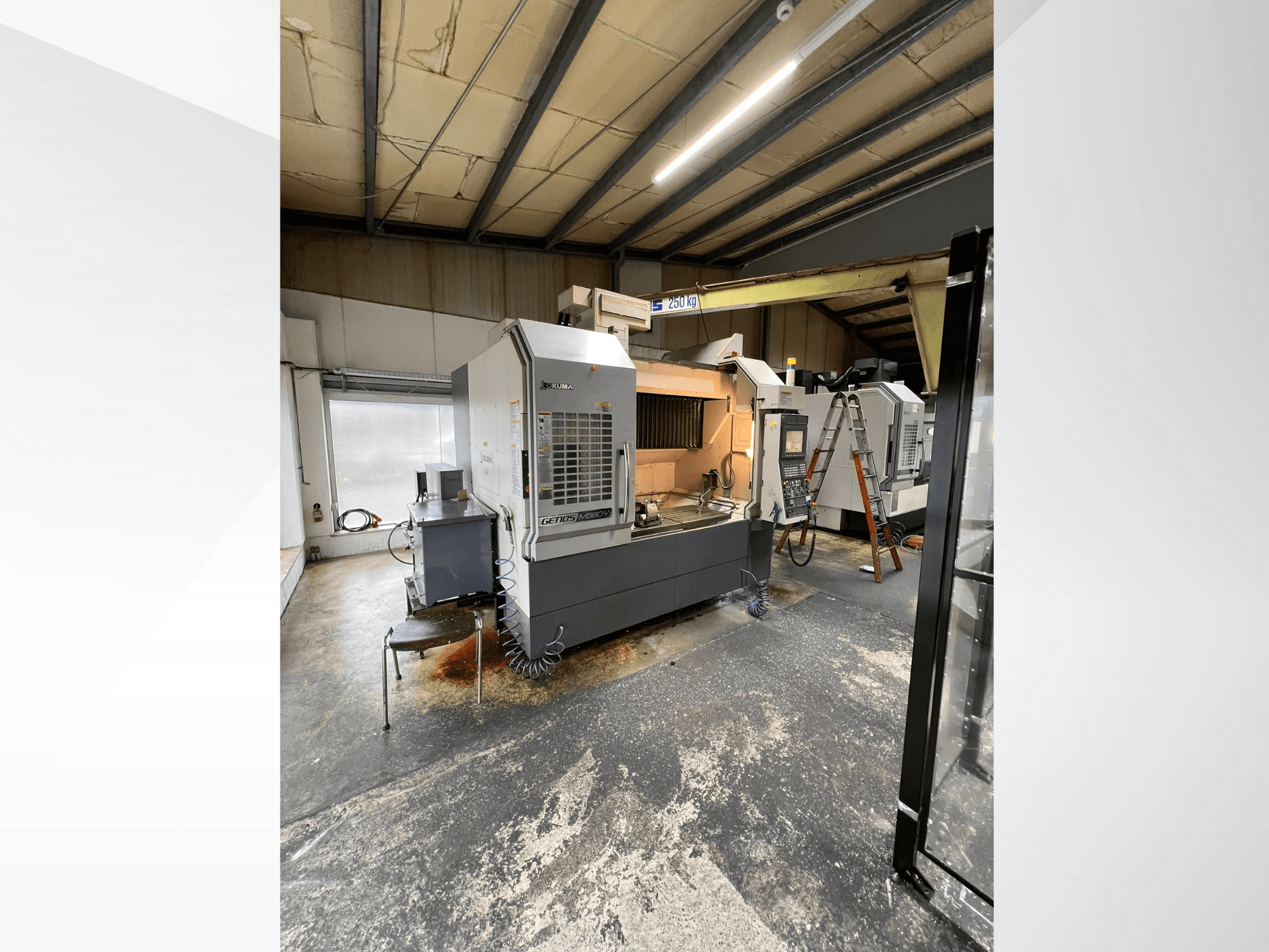 GRETOS 750 CNC machine in a workshop, front view, showing control panel and work area with tools, visible ladder in background.
